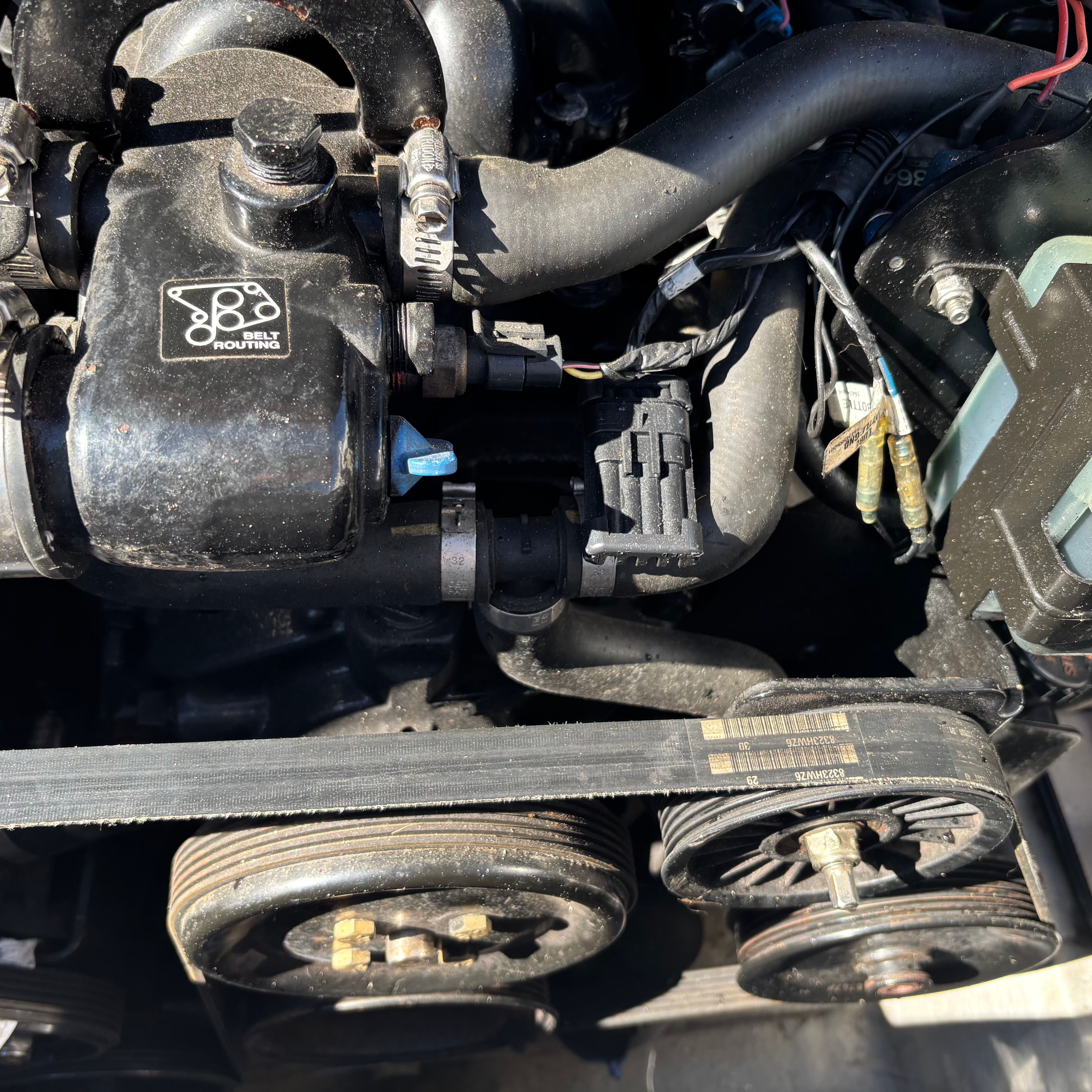 Close-up of a boat engine with belts and wires.