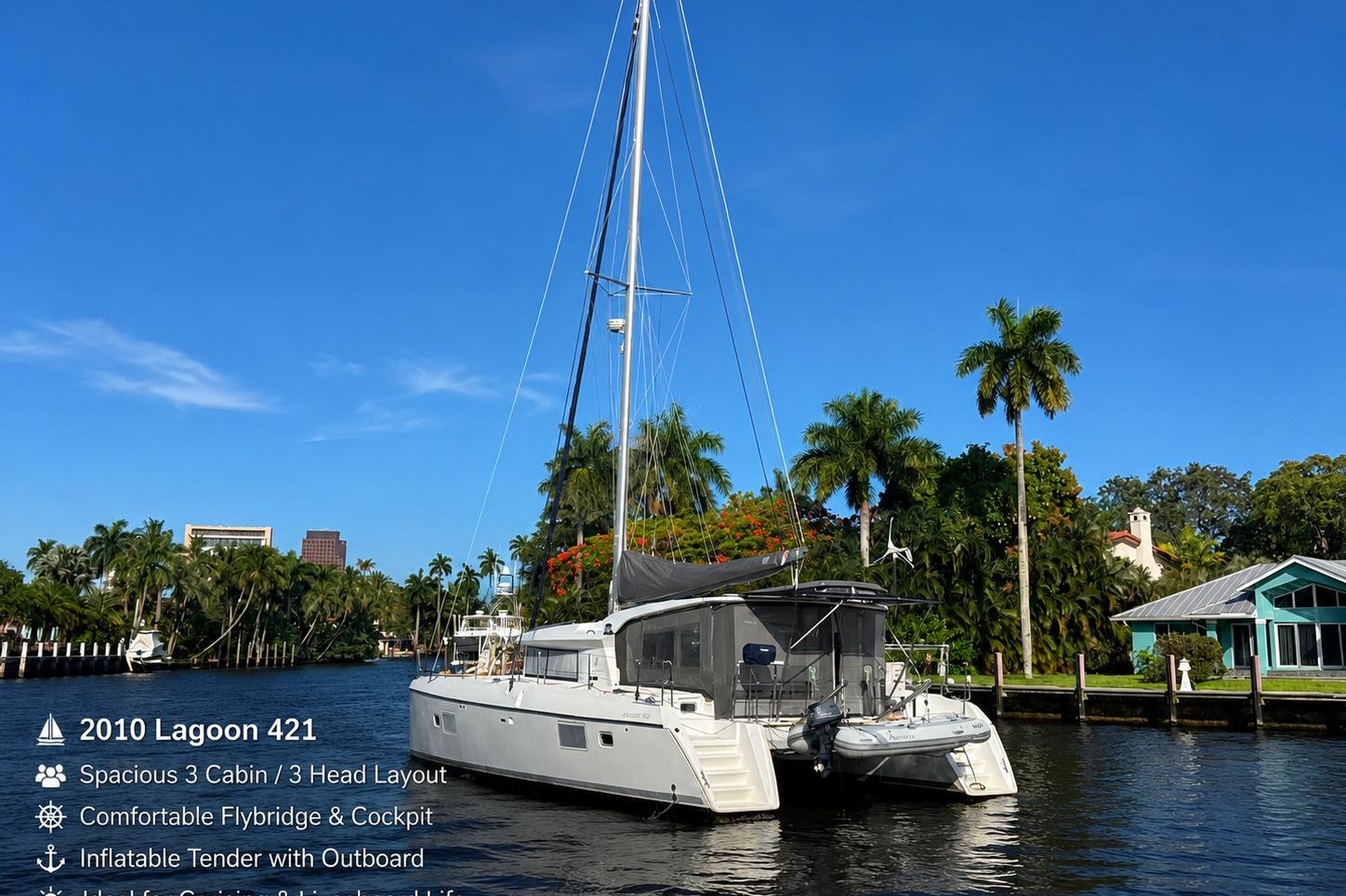 2010 Lagoon 421 catamaran on a serene waterway, surrounded by lush palm trees and clear blue sky.