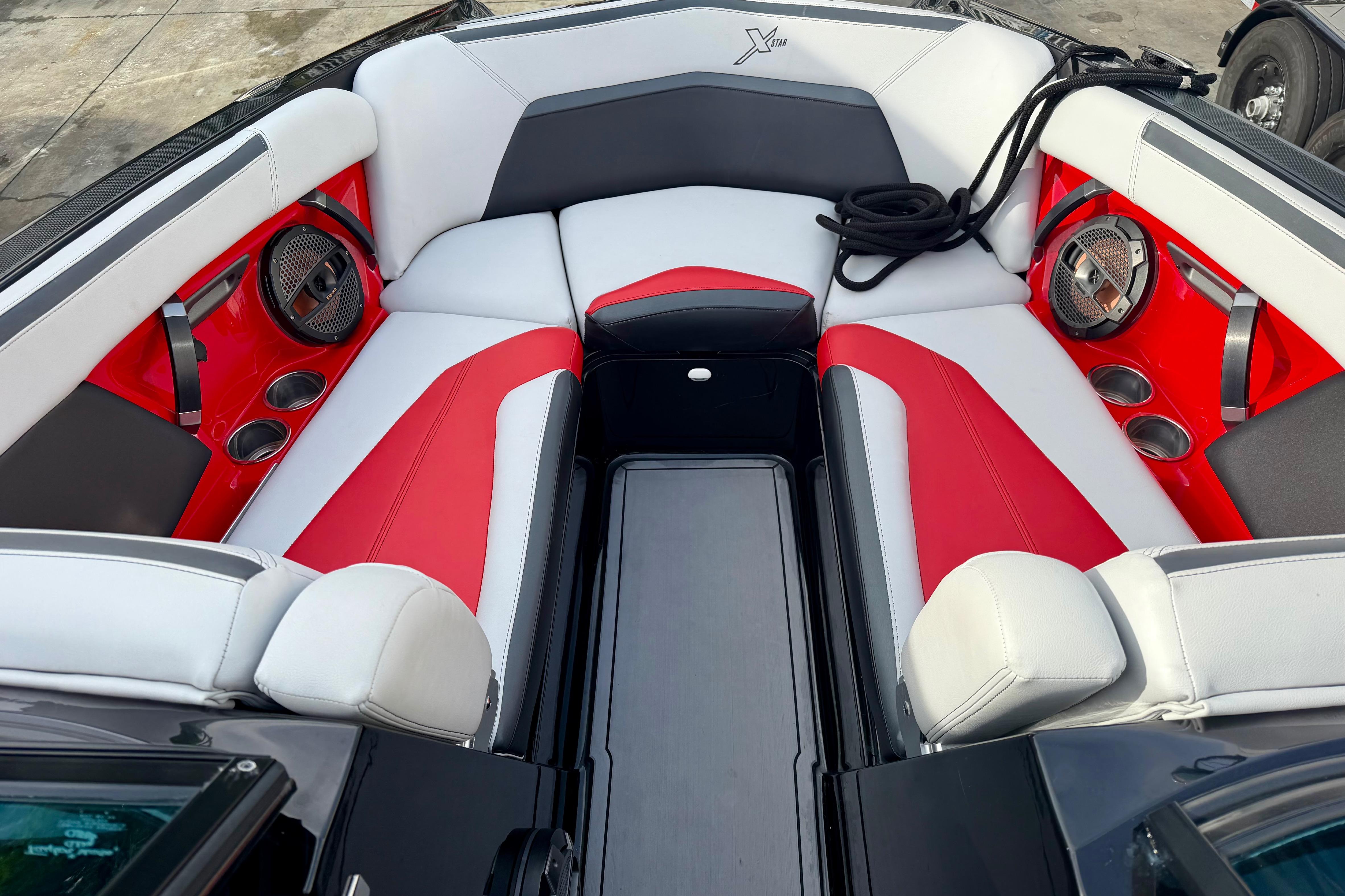 2019 MasterCraft XStar boat interior with red and white seating, cup holders, and speakers.