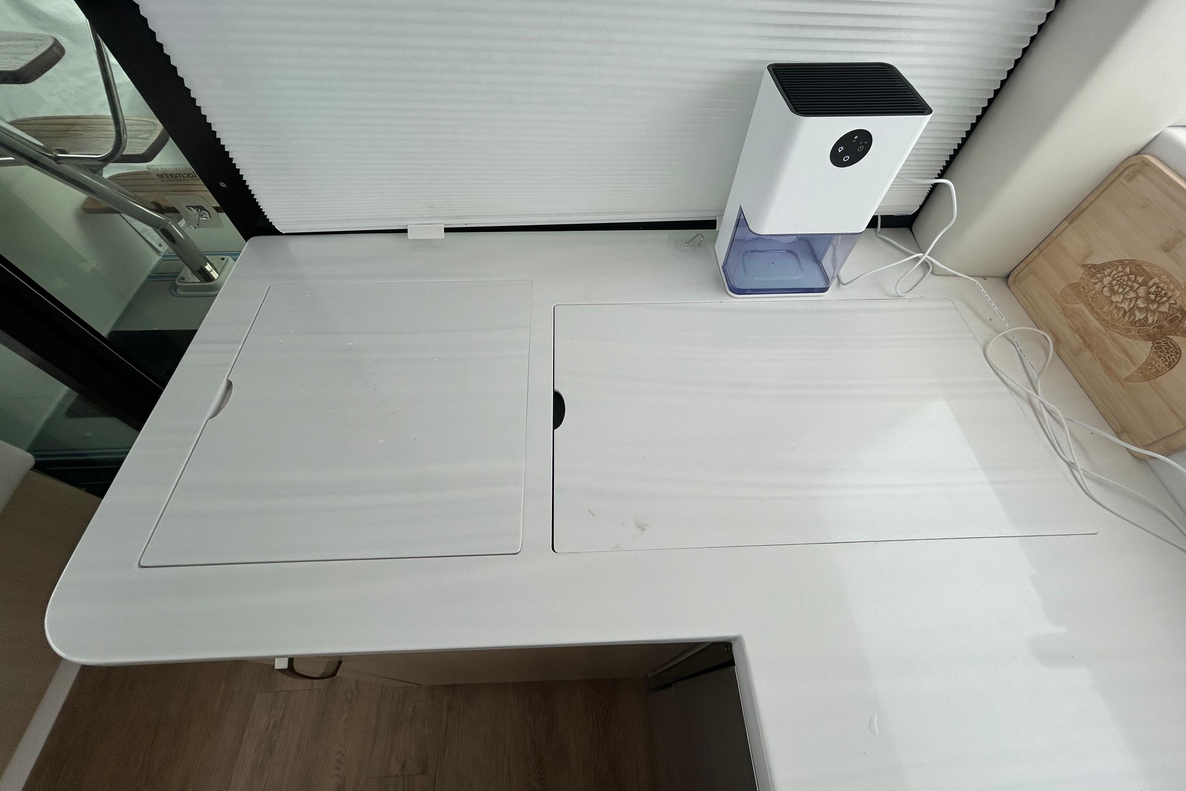Modern kitchen counter on 2023 Regal 38 FXO yacht with appliance and cutting board.