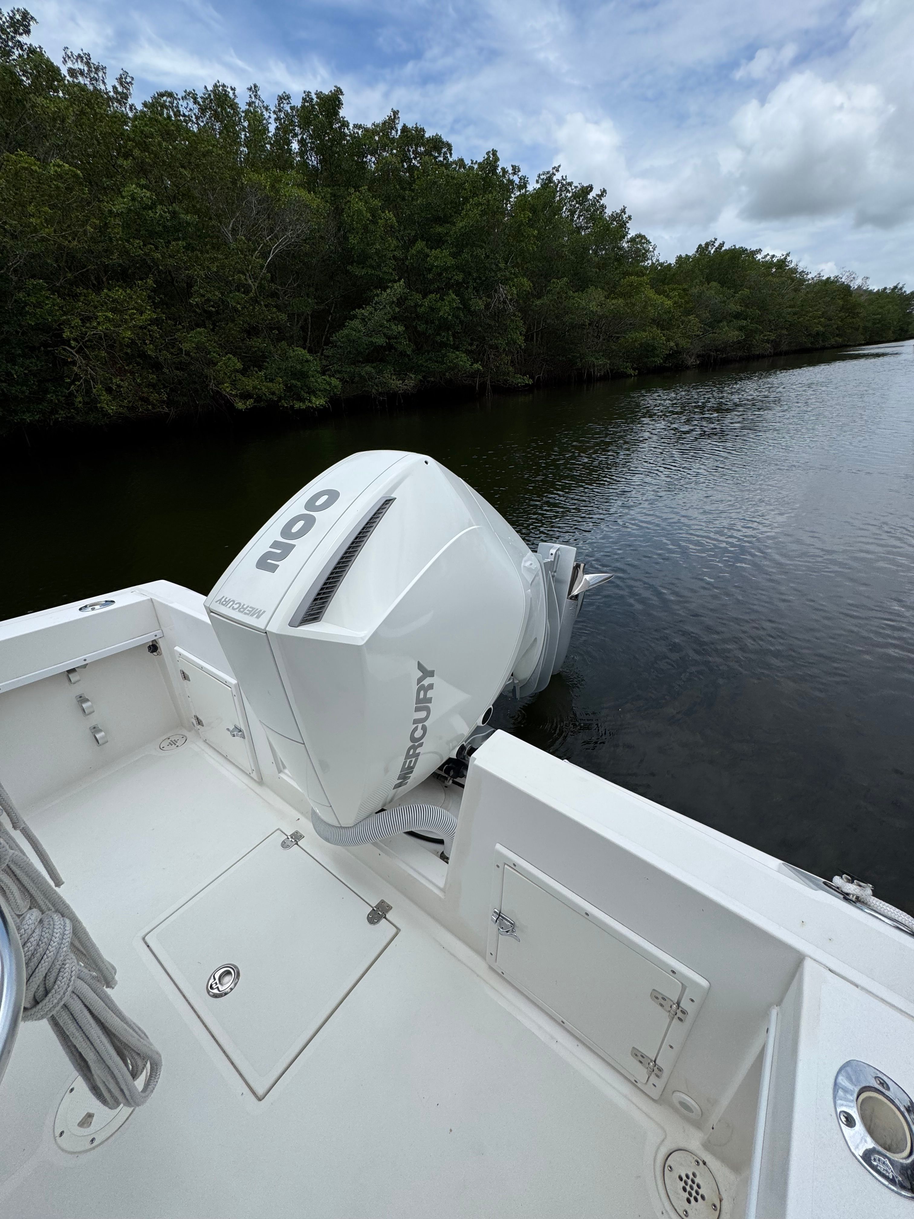A 2004 Contender 21 boat with a Mercury outboard motor on a calm river.