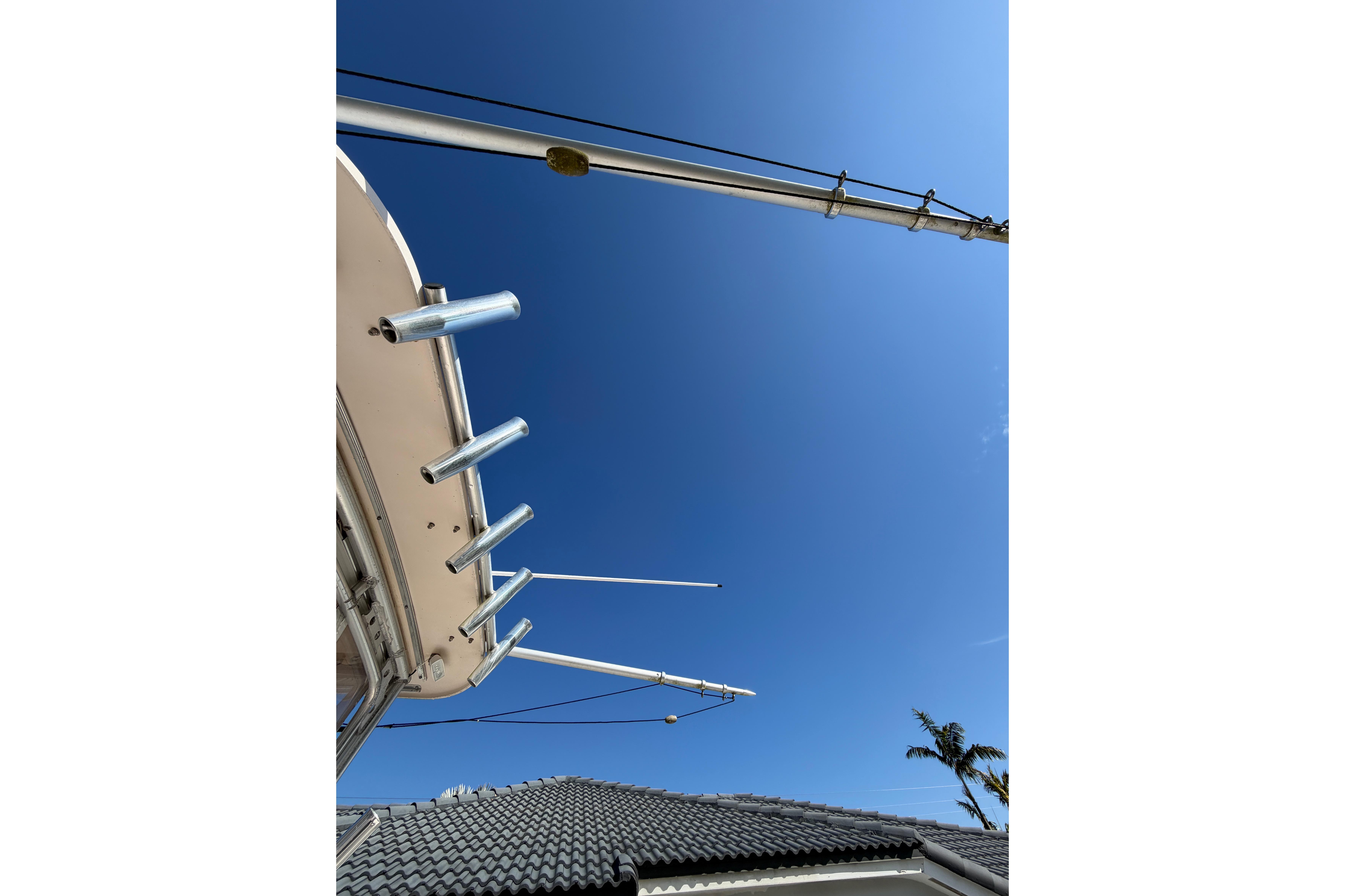 2006 Grady-White Sailfish 282 boat outriggers against clear blue sky.
