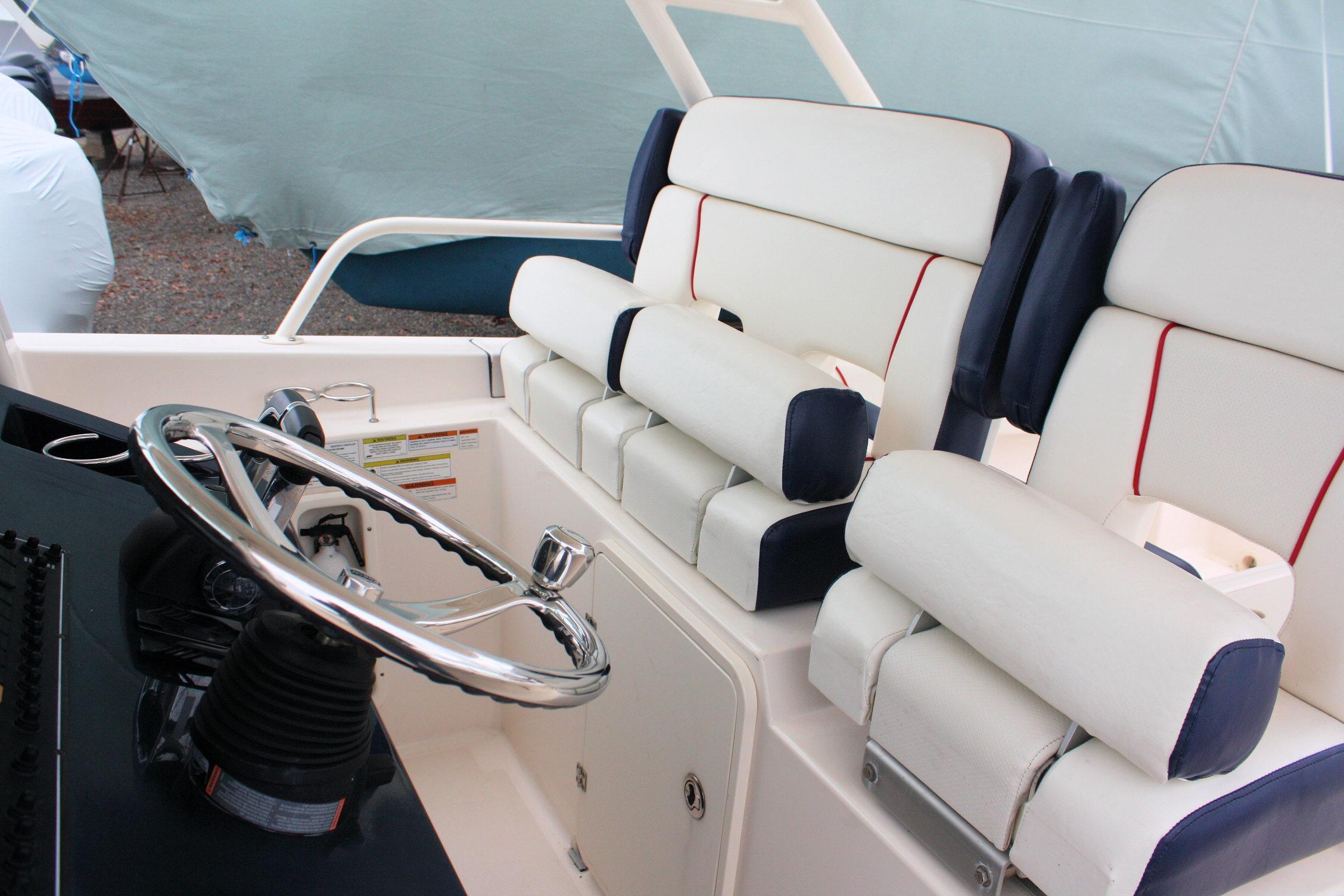 2013 Pursuit ST 310 Sport boat interior with steering wheel and cushioned seating.