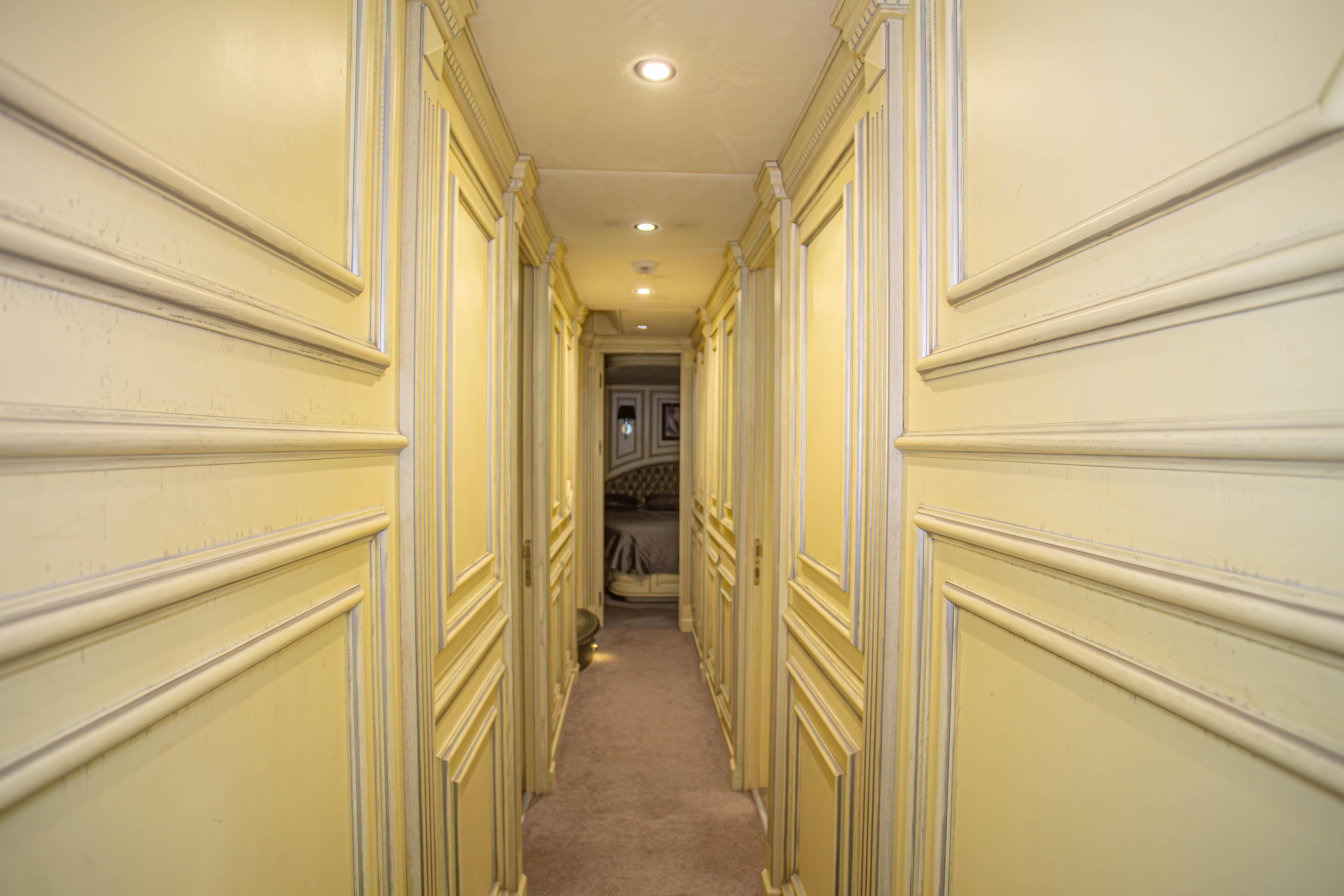 Elegant hallway in 2014 Fifth Ocean Yachts 24m Displacement Explorer Yacht, featuring classic paneling.