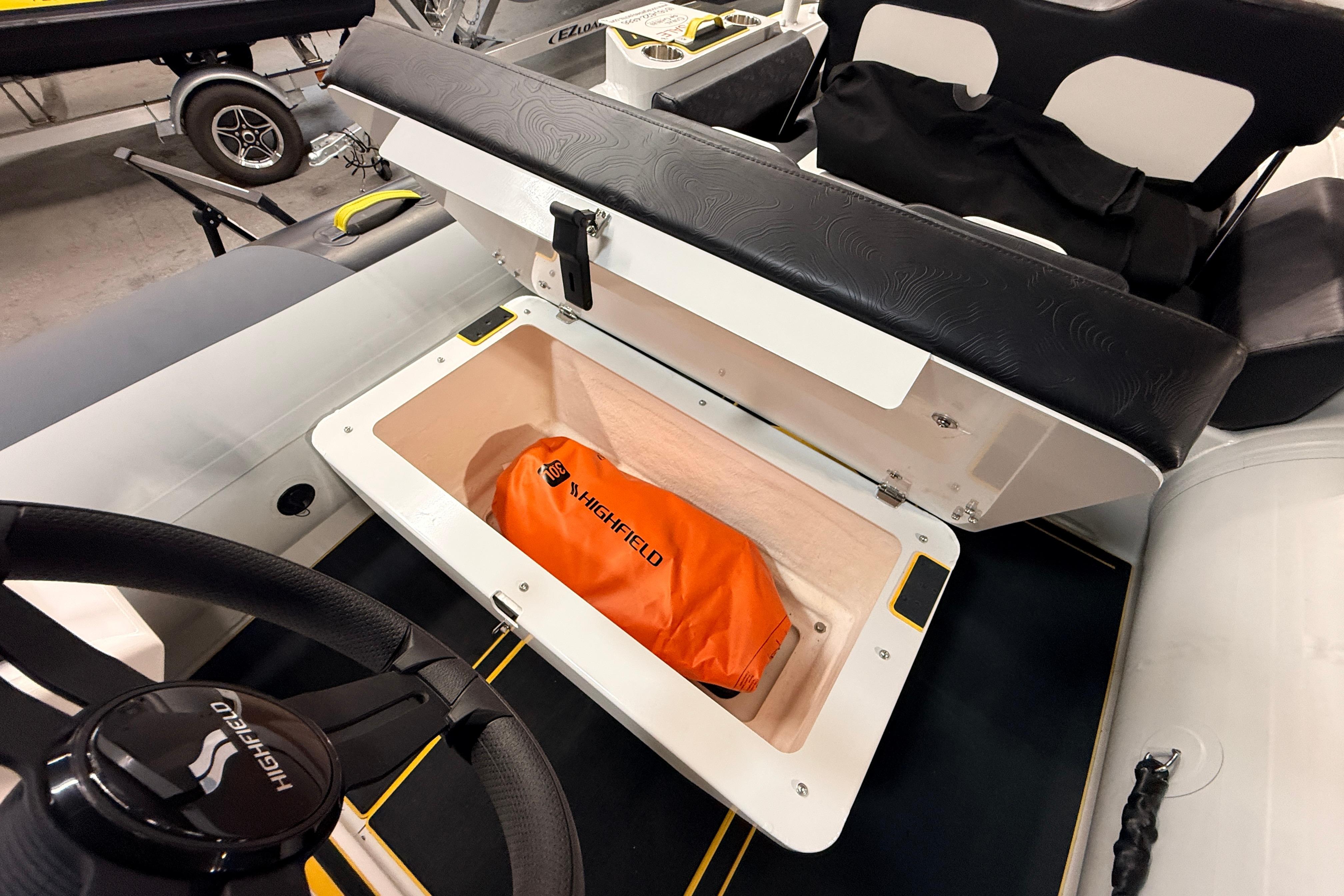 2026 Highfield VELOX 560 boat storage compartment with orange Highfield bag inside.