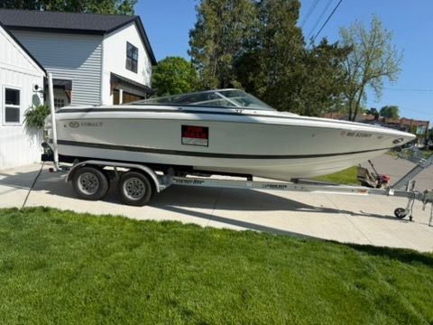 A 2001 Cobalt 226 boat is on a trailer in a driveway.