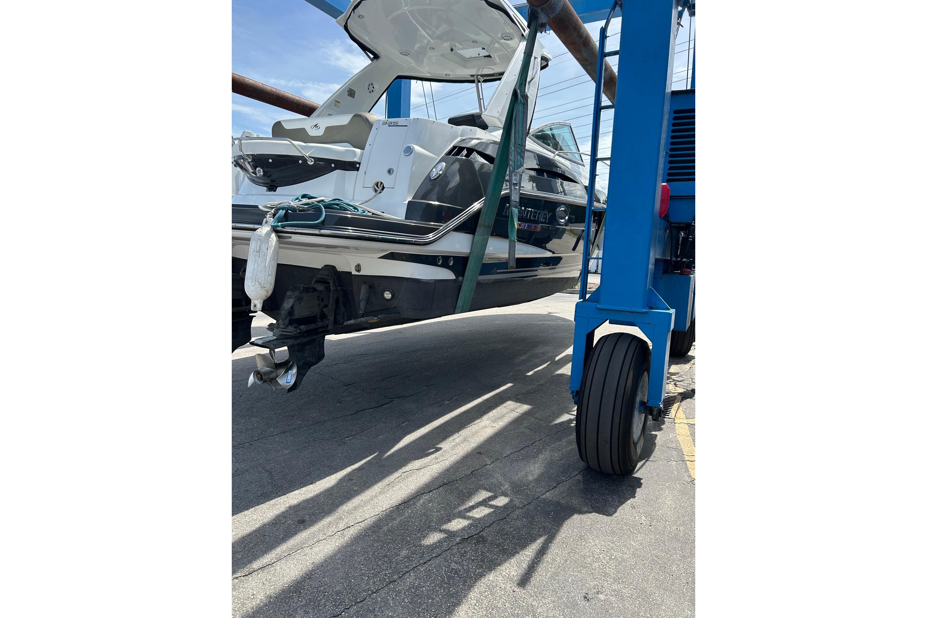 2019 Monterey 335 Sport Yacht being lifted by a blue crane on a sunny day.