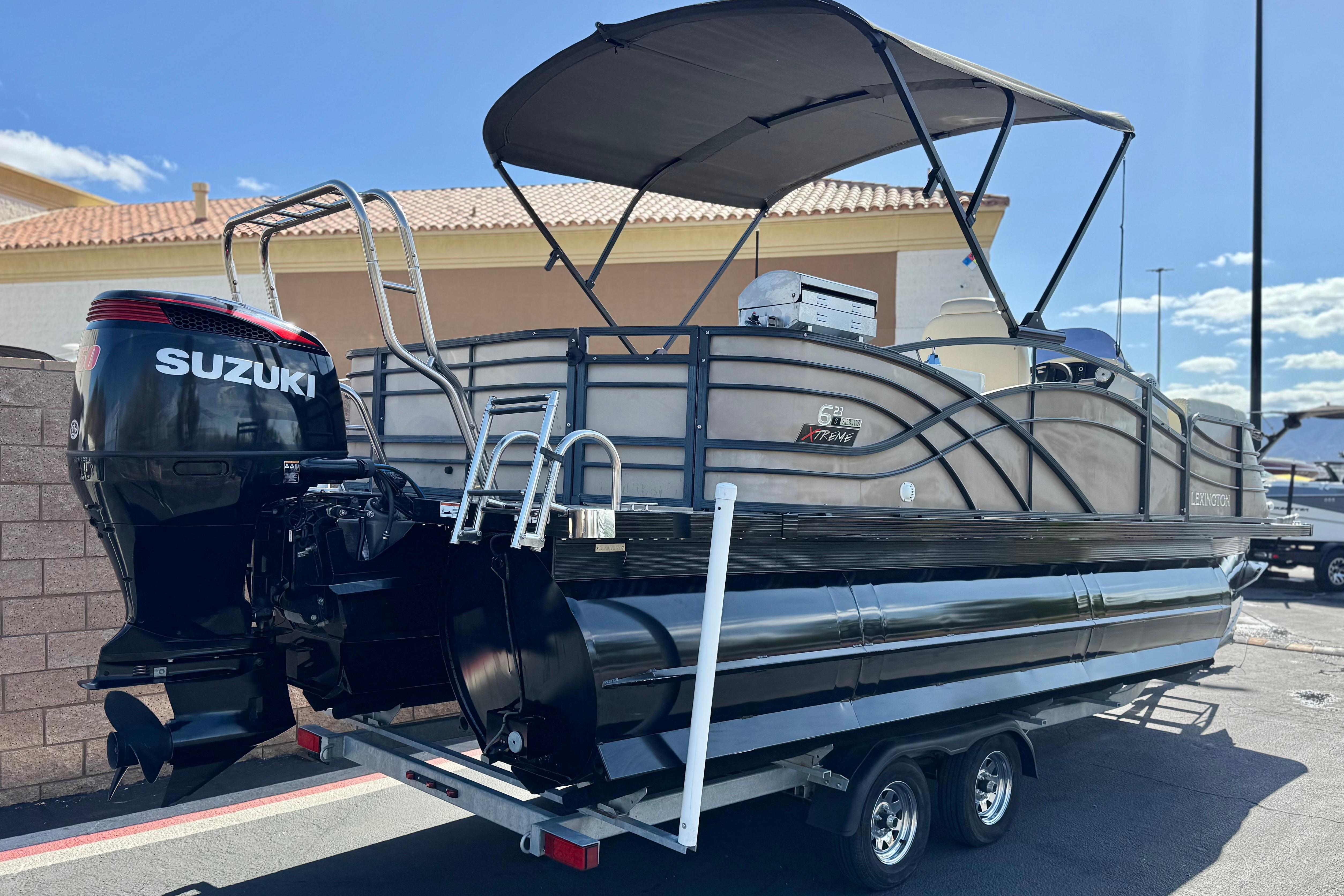 2023 Lexington 623 ST Xtreme pontoon boat with Suzuki outboard motor on trailer.