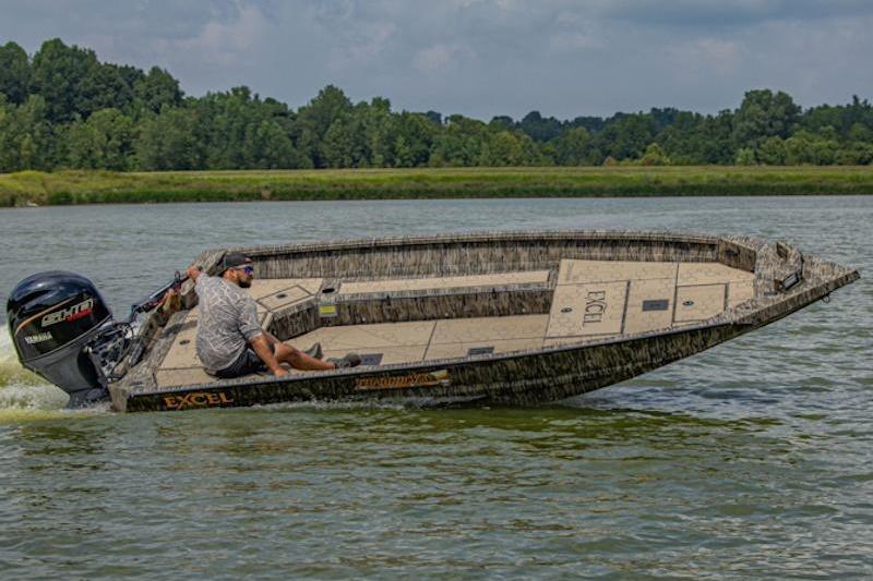 Man driving 2026 Excel 183 Tomahawk boat on a calm lake.