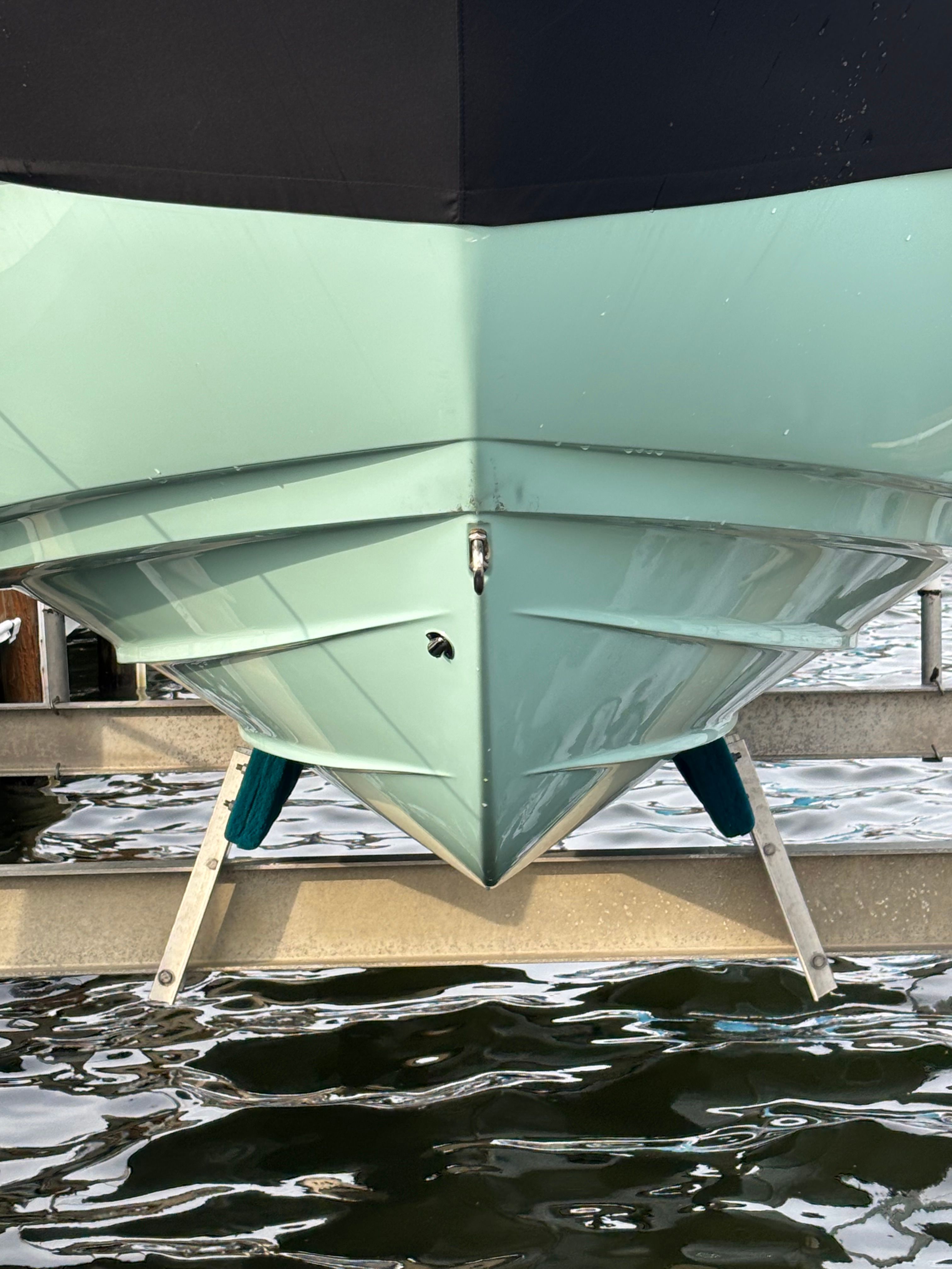 A 2024 Yamaha AR250 boat with a turquoise hull is docked on the water.
