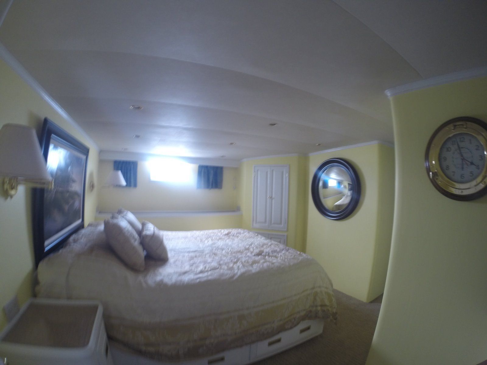 Interior of a 1963 Burger Flush Deck yacht, bedroom with bed and clock.