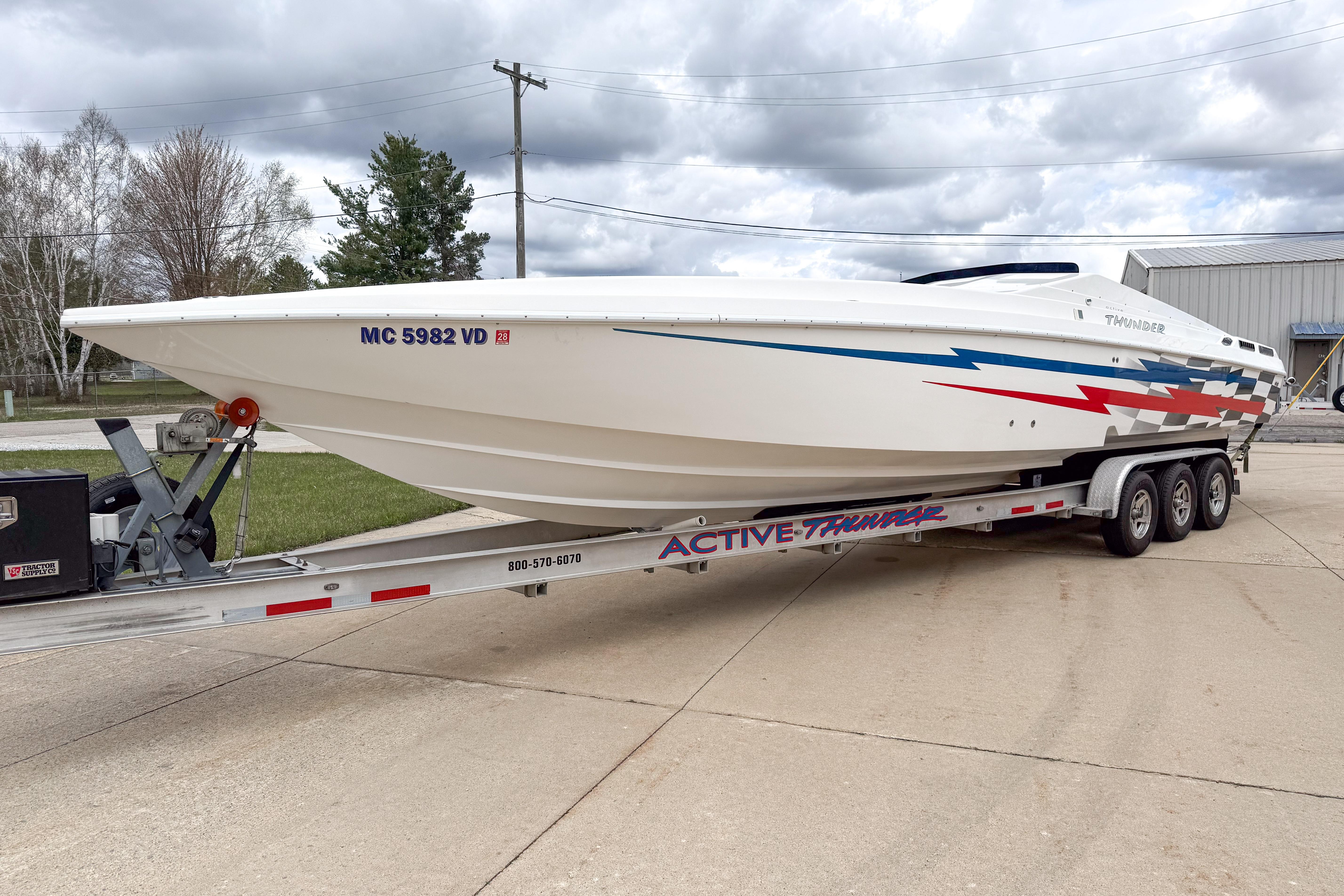 2002 Active Thunder 37 boat on trailer, featuring sleek design and vibrant graphics.