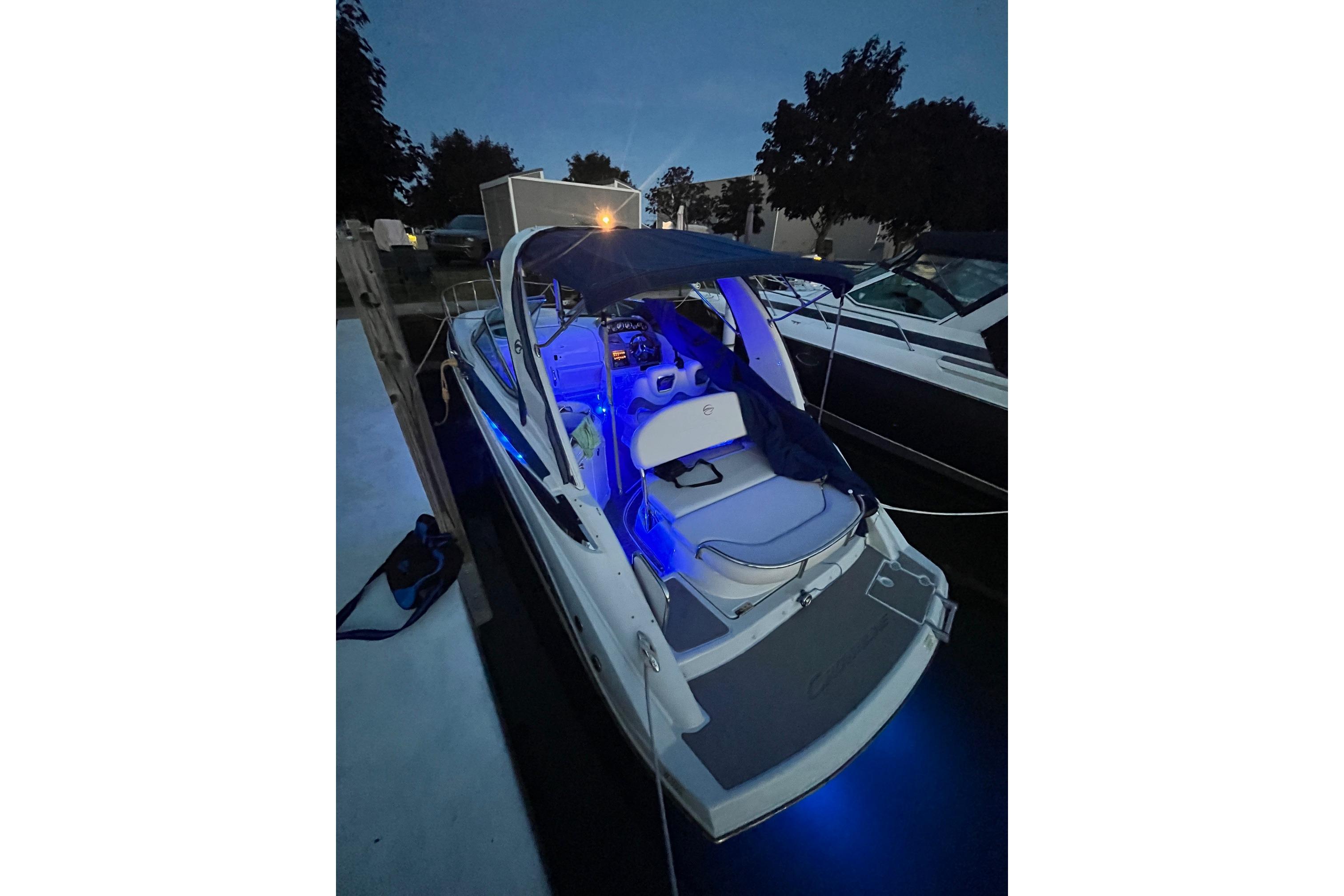 2016 Crownline 264 CR boat docked at night with blue interior lighting.