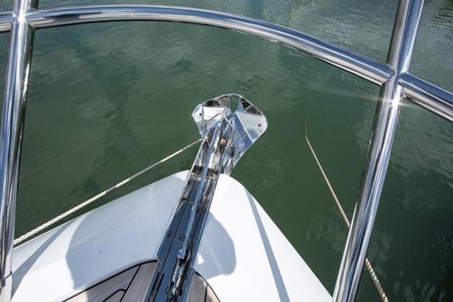 Bow view of 2024 Princess V55 yacht with anchor and railing over water.