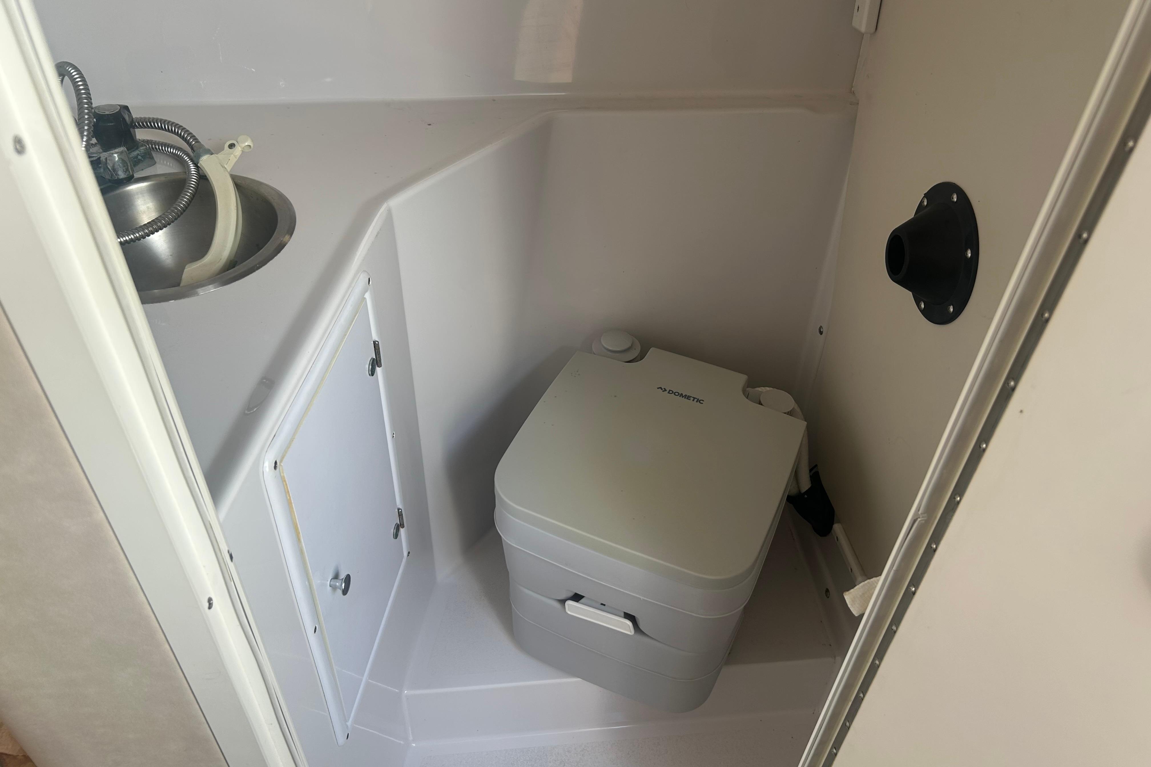 1998 Four Winns 258 Vista boat bathroom with compact sink and portable toilet.