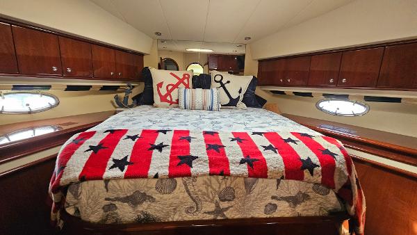 Luxurious 2005 Neptunus 56 Flybridge yacht bedroom with nautical-themed decor.
