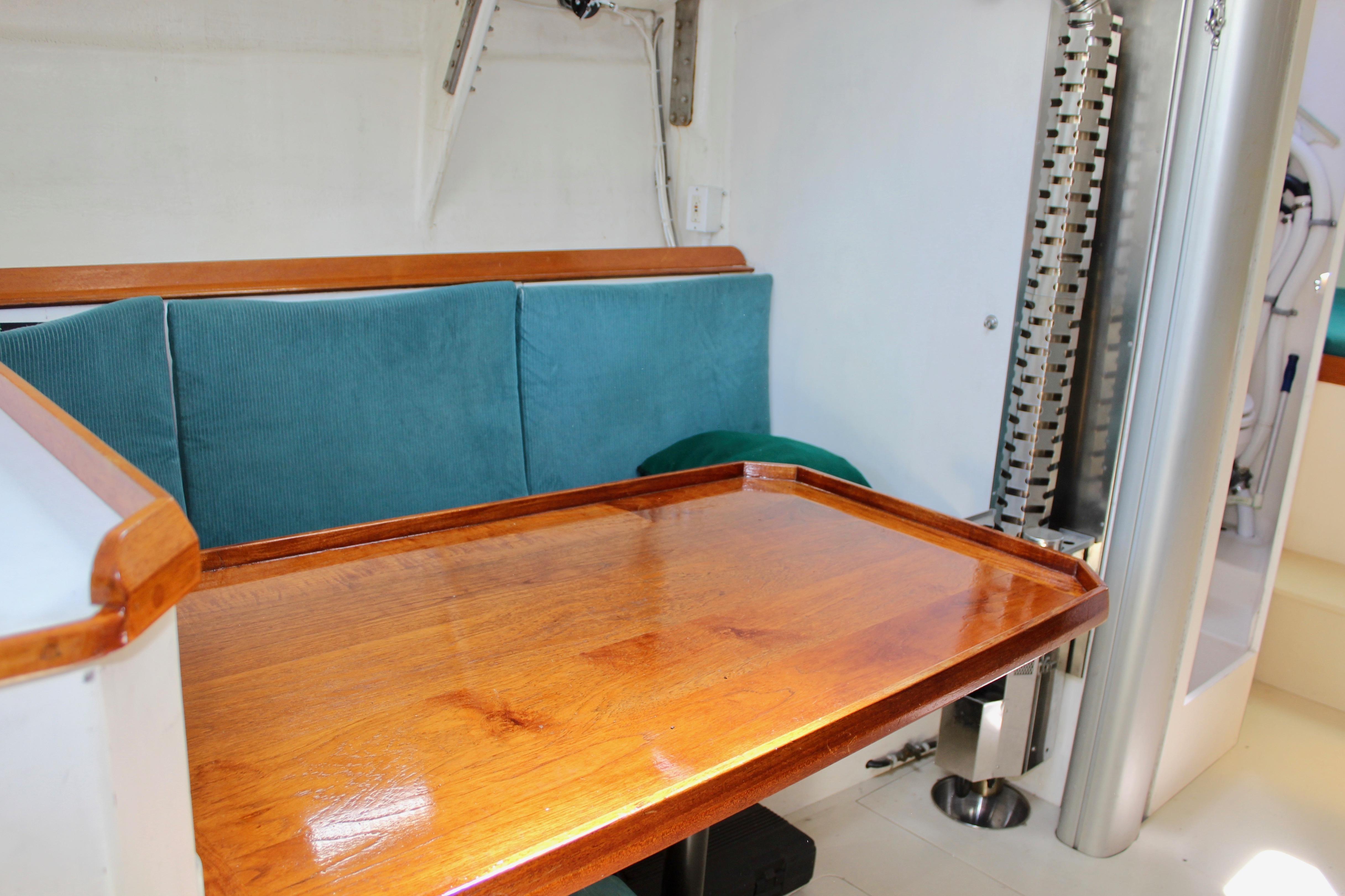 Interior of 1993 Freya 39 yacht with wooden table and teal seating.