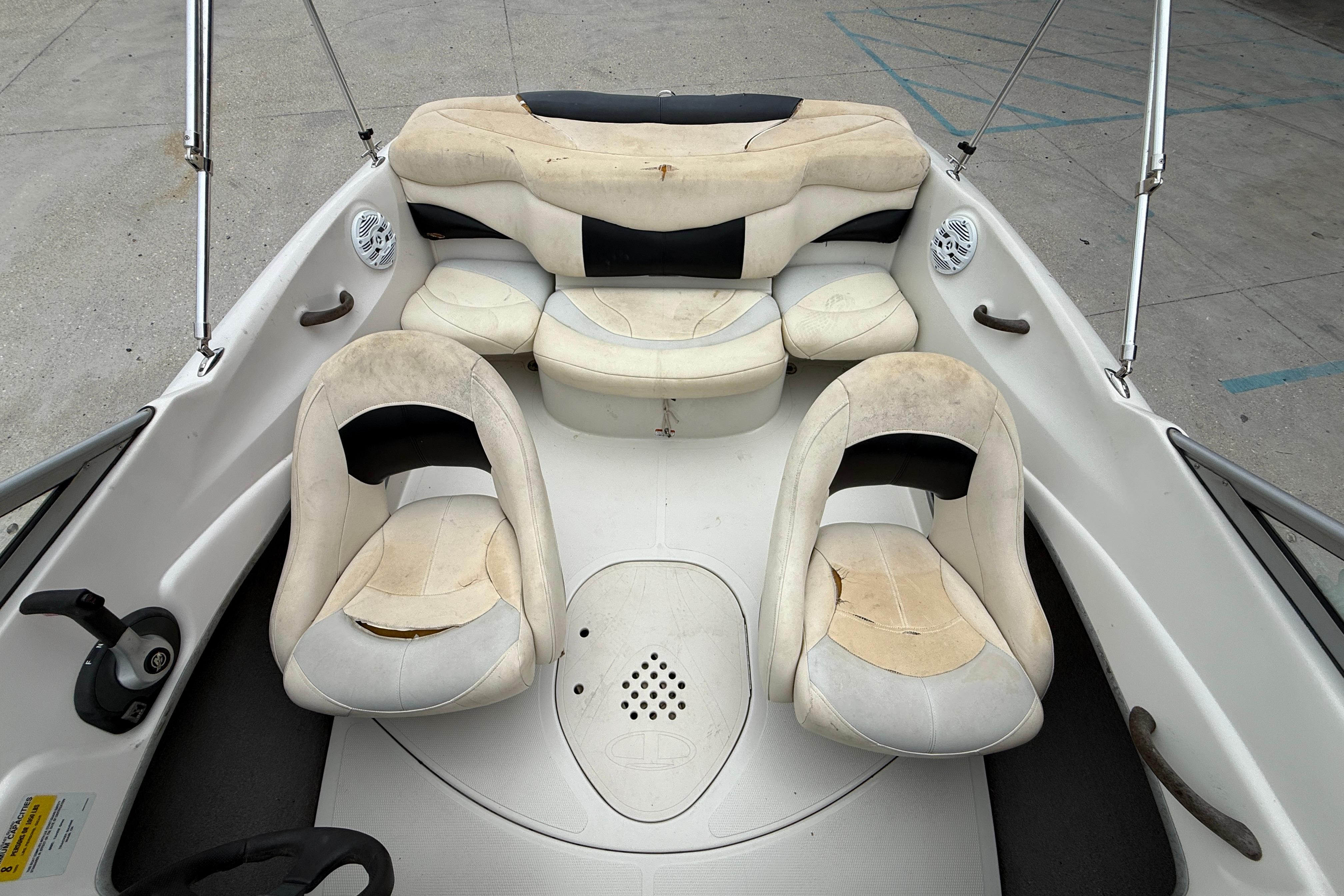 2010 Tahoe Q4 boat interior with worn white and black seating.