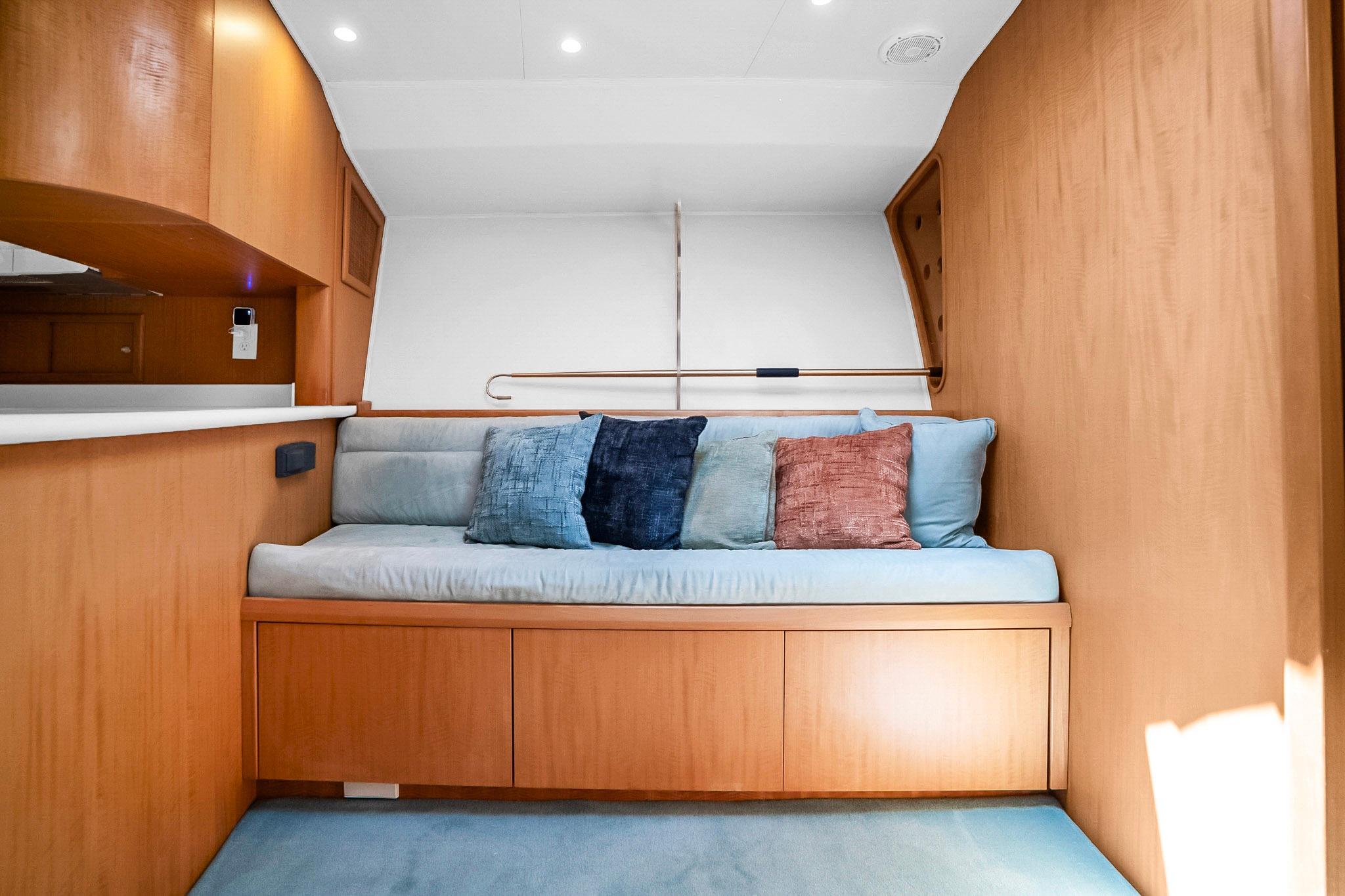 Cozy interior of 2006 Dixon 52 yacht with cushioned seating and wooden accents.