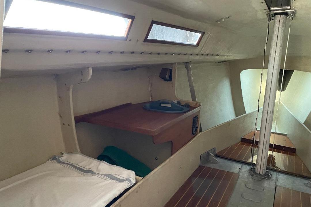 1985 S2 K sailboat interior with wooden accents and sleeping area.
