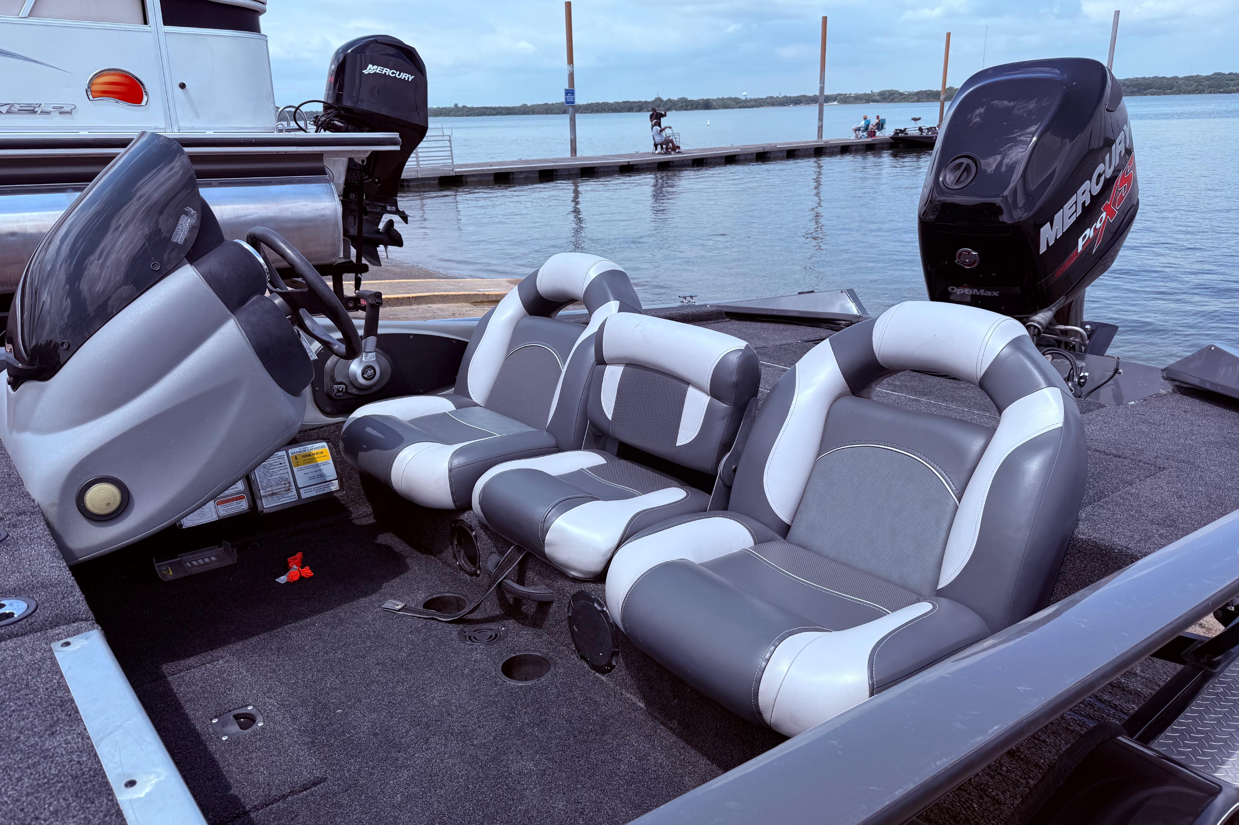2015 Tracker Pro Team 190 TX boat interior with gray and white seating, docked by a lake.