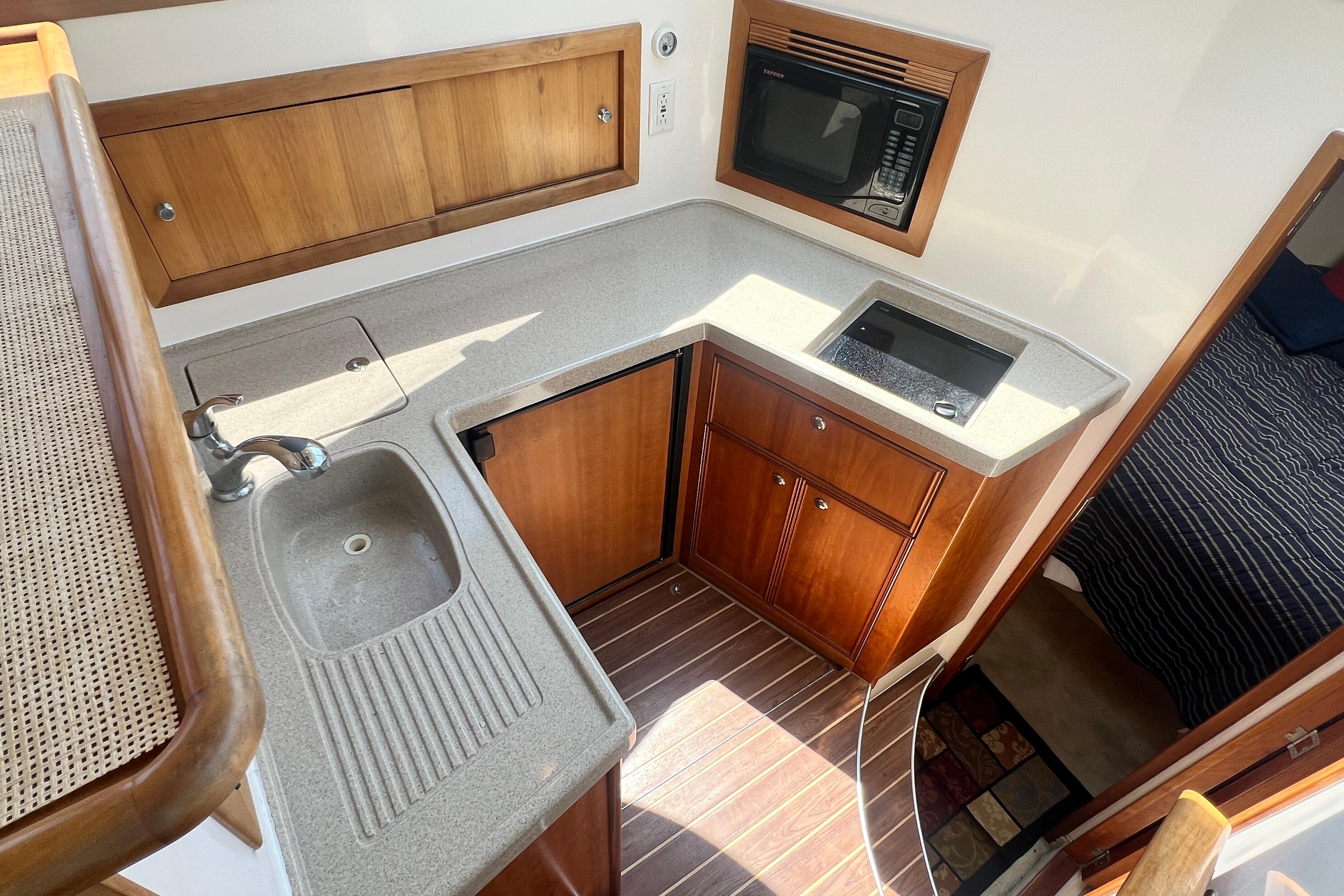 2007 Riviera 33 Flybridge yacht kitchen with sink, stove, and microwave.
