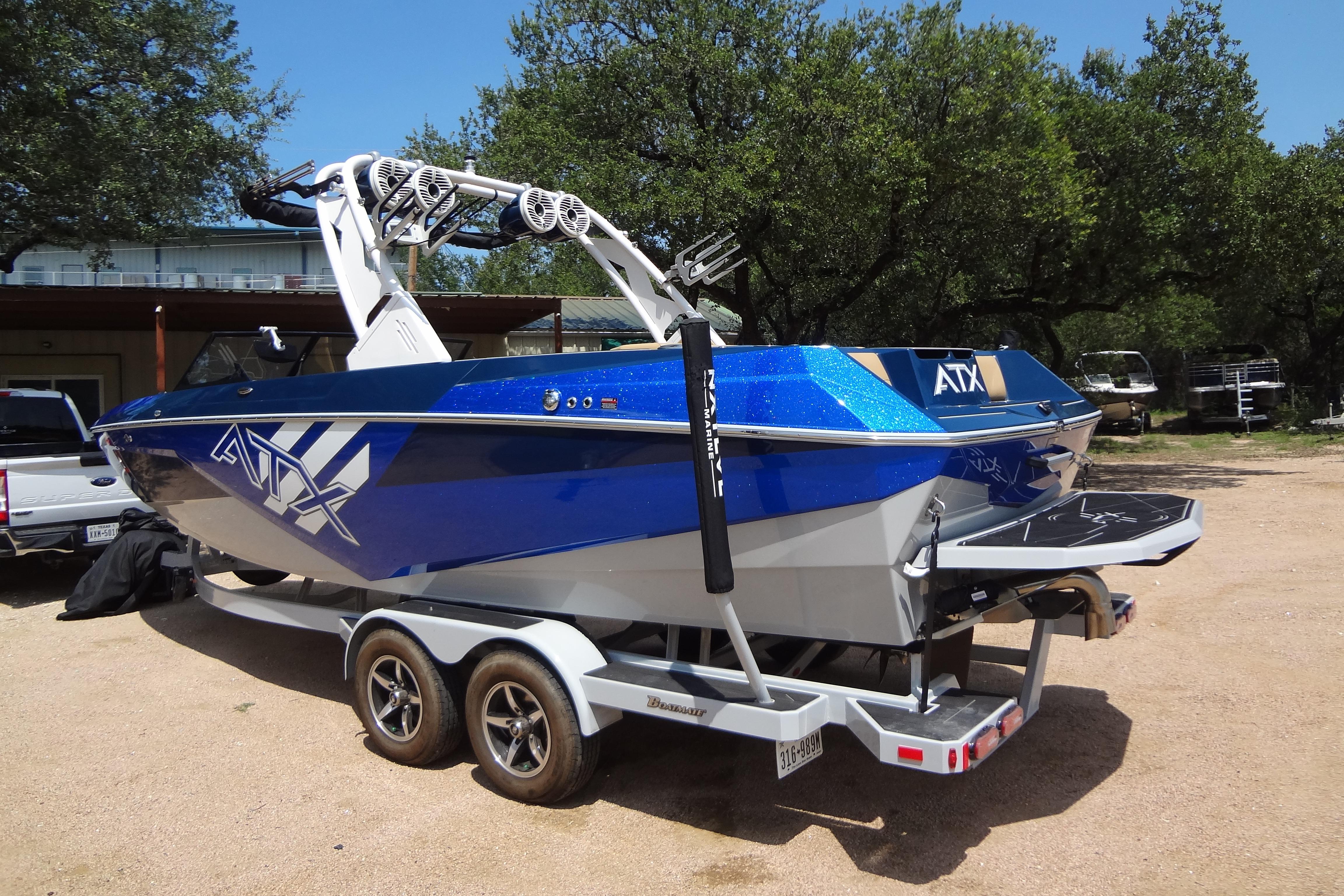 2022 ATX Surf Boats 24 Type-S in vibrant blue on a trailer, parked outdoors.