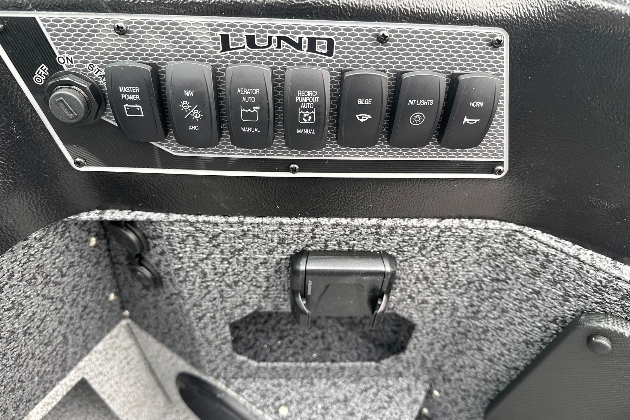 Control panel of 2026 Lund 1775 Impact XS Sport boat with various switches.