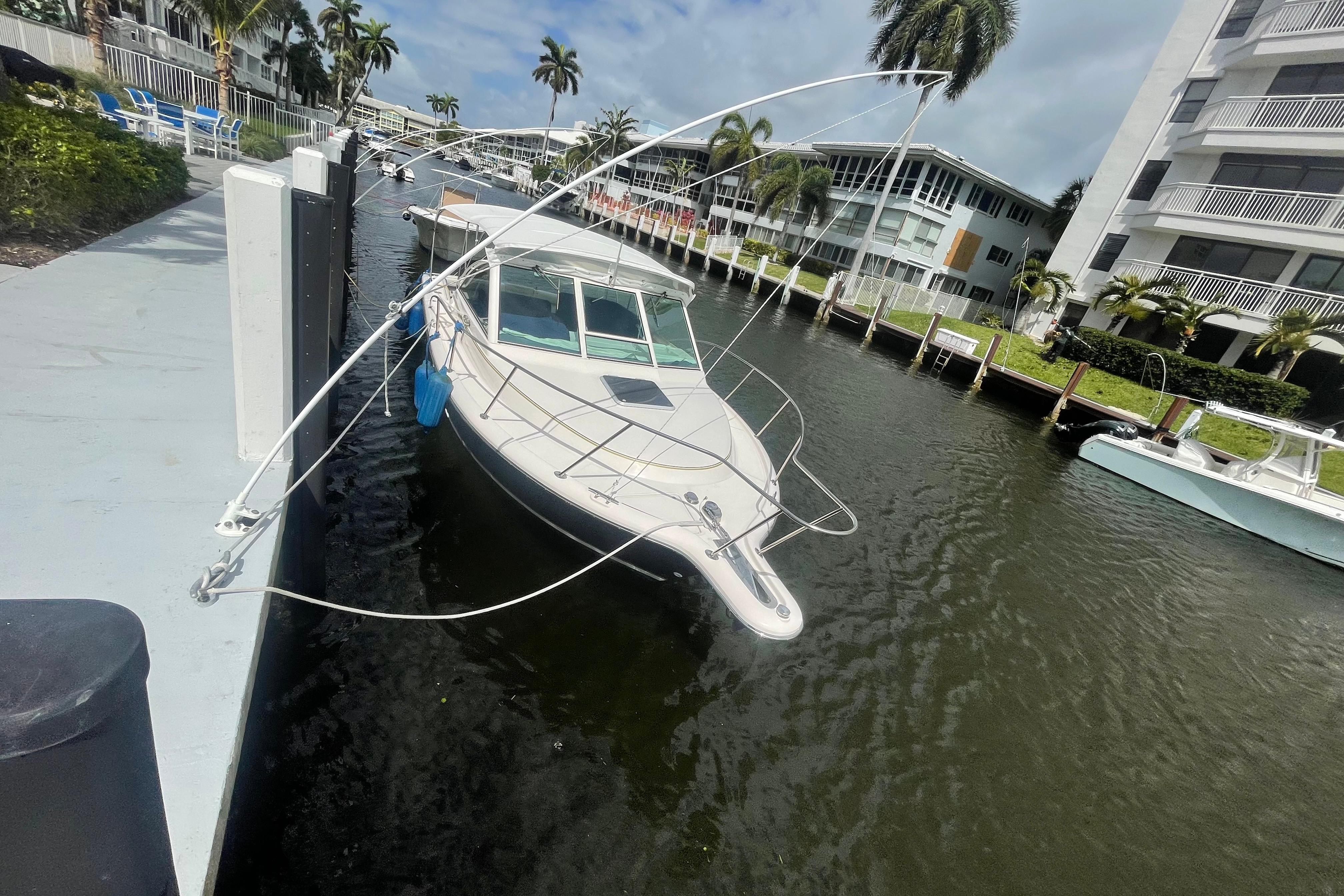 2001 Tiara Yachts 2900 Coronet docked in a scenic canal with palm trees.