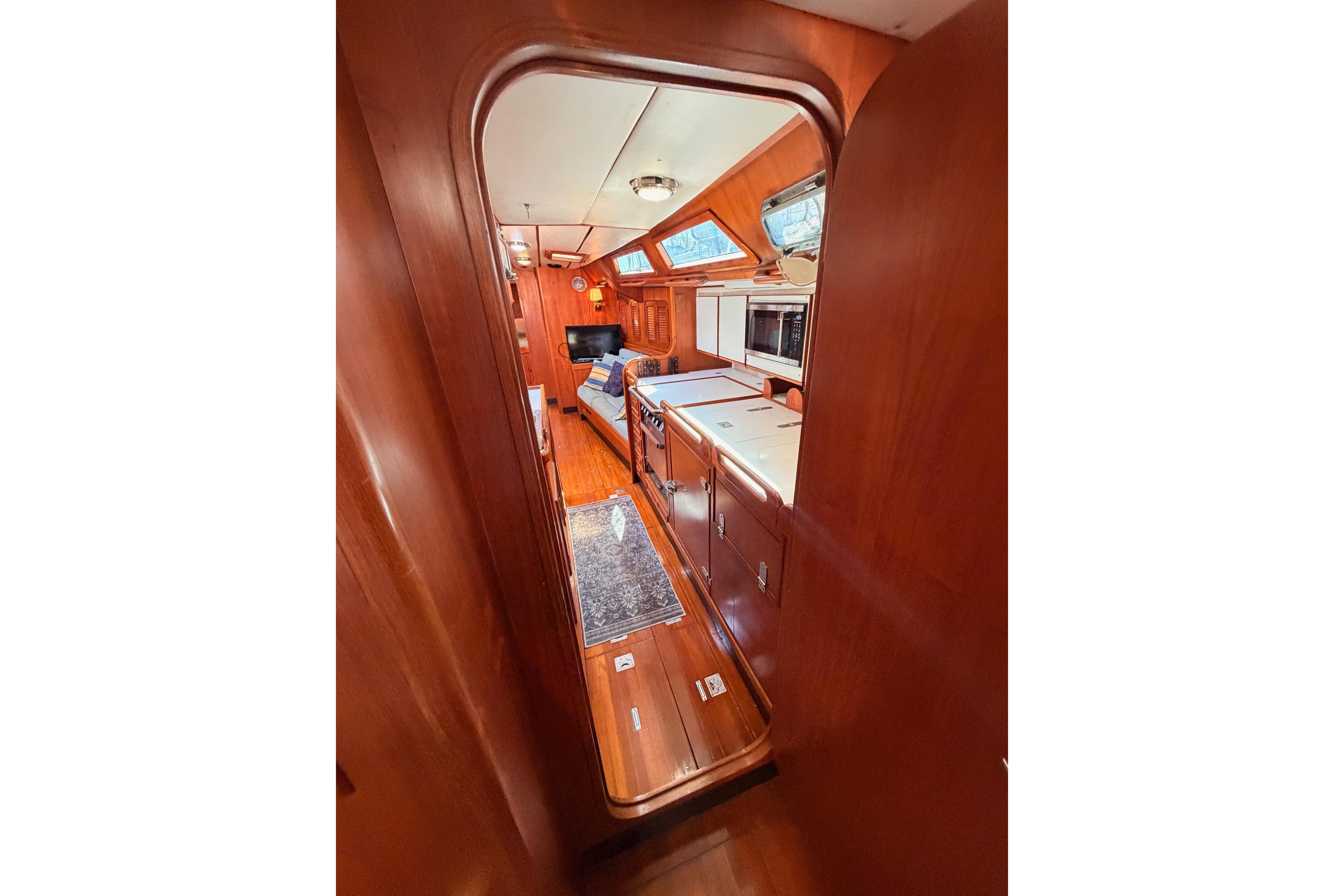 Interior view of 1991 Hylas 51 yacht, featuring wooden cabinetry and modern amenities.