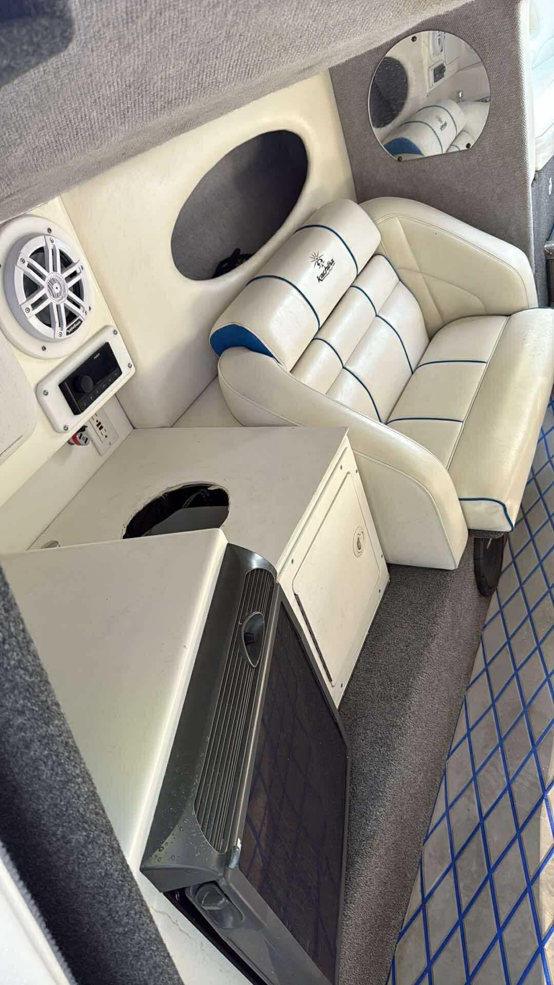Interior of a 2005 Kachina Bolero boat with white seating and built-in speaker.