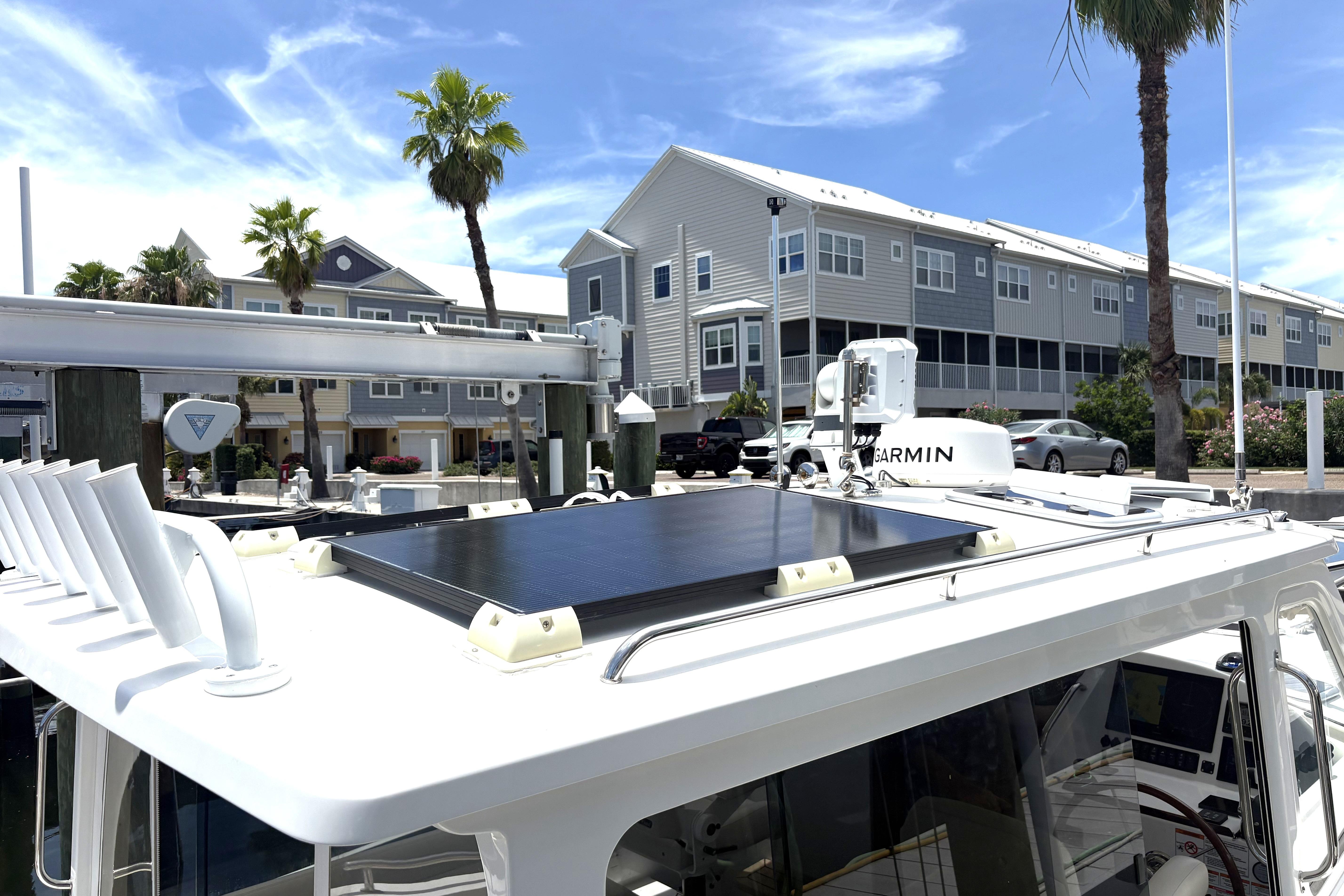 2024 MJM 35z boat with solar panel, docked near modern buildings and palm trees.