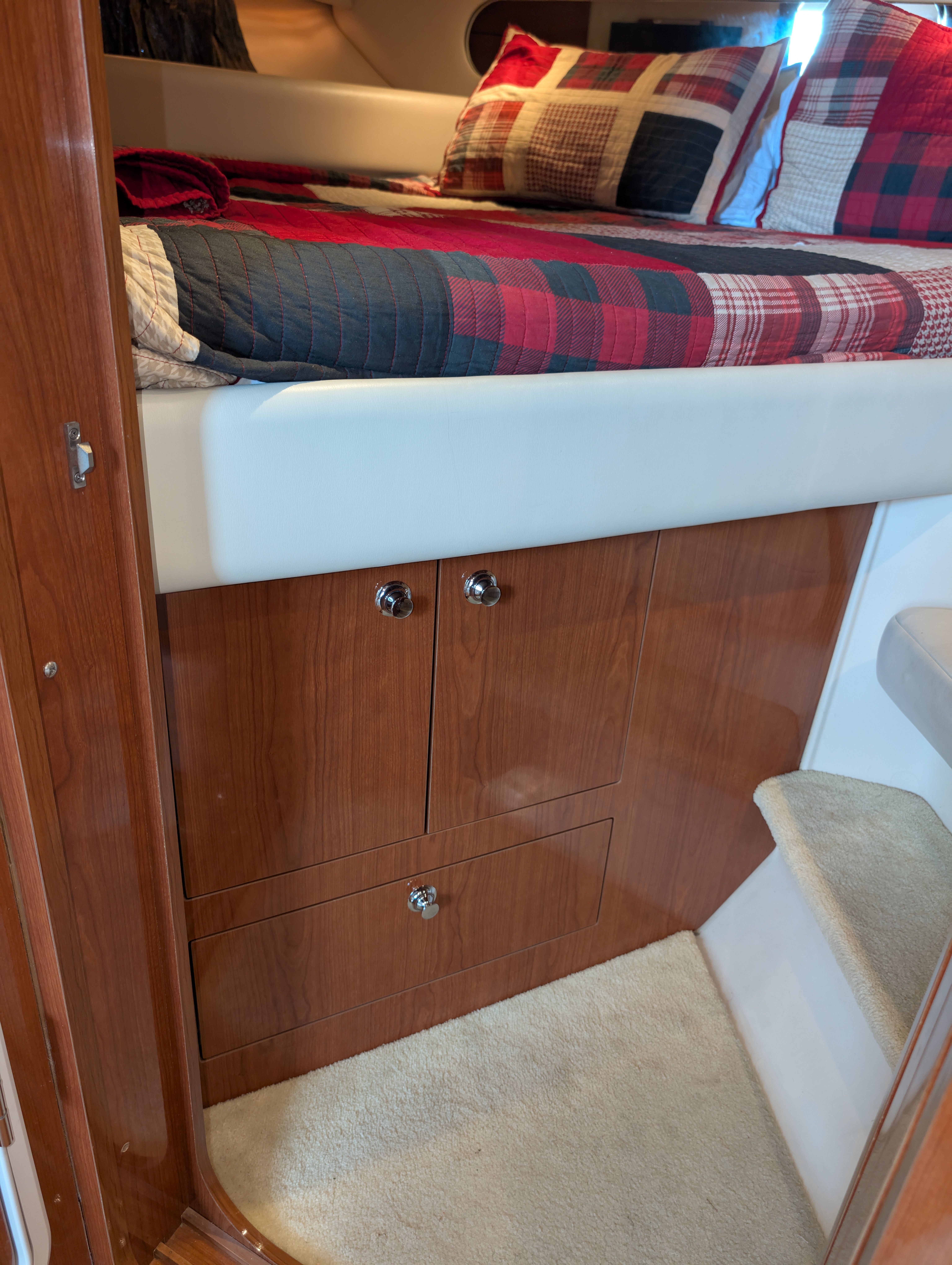 Interior of a Regal Commodore 3560 yacht with bed and wooden cabinets.