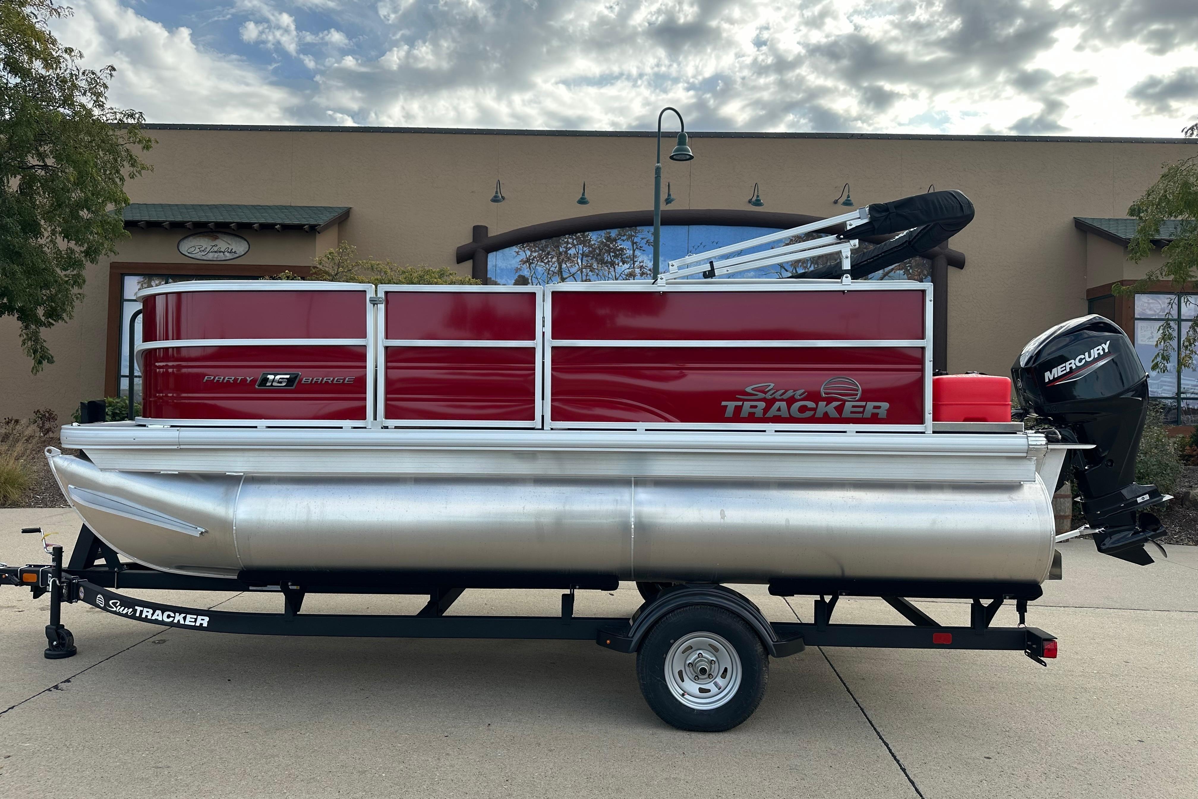 2026 Sun Tracker Party Barge 16 DLX pontoon boat on trailer, outdoor setting.