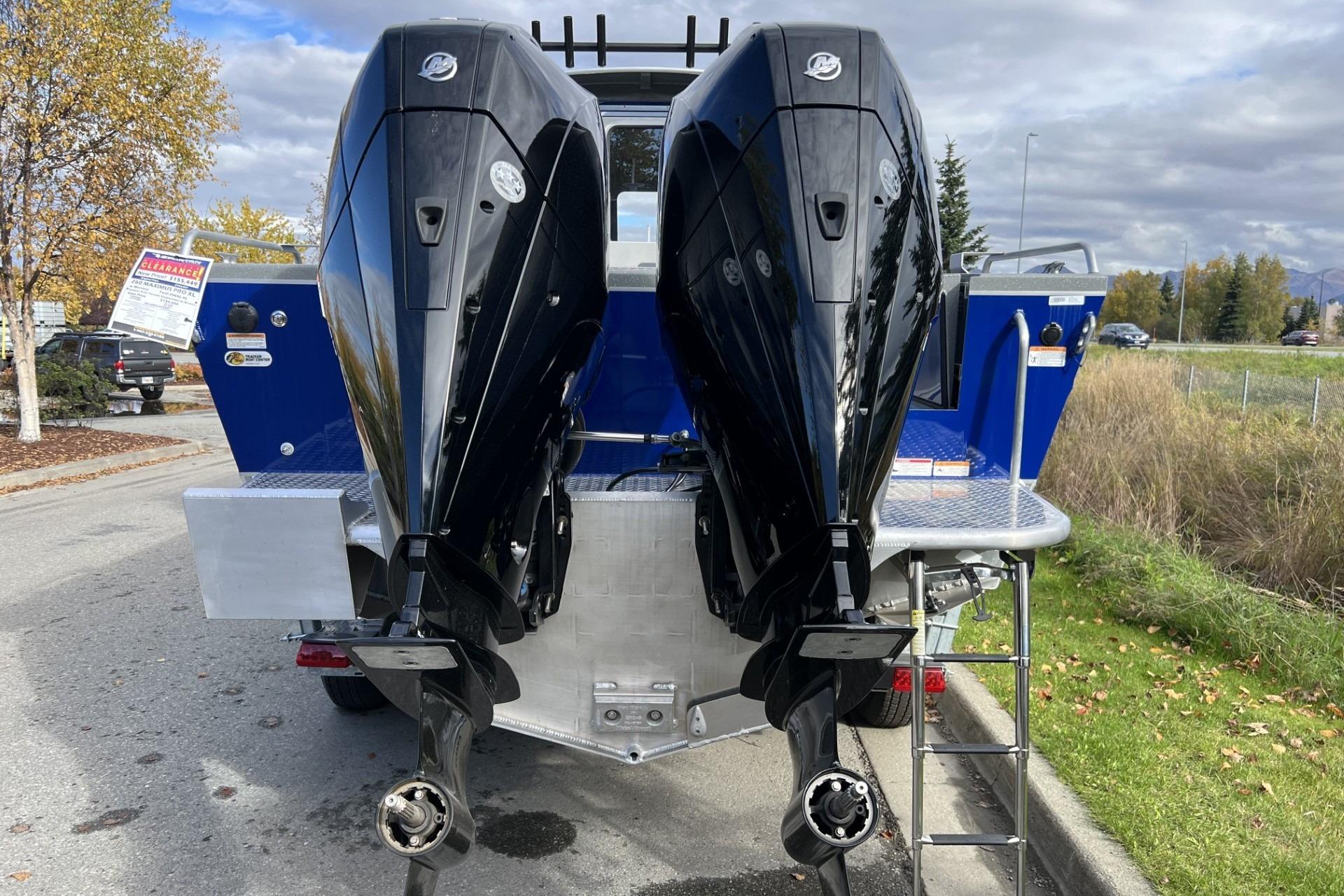 2024 Spartan 26 Maximus Pro XL boat with dual outboard motors, parked on a street.