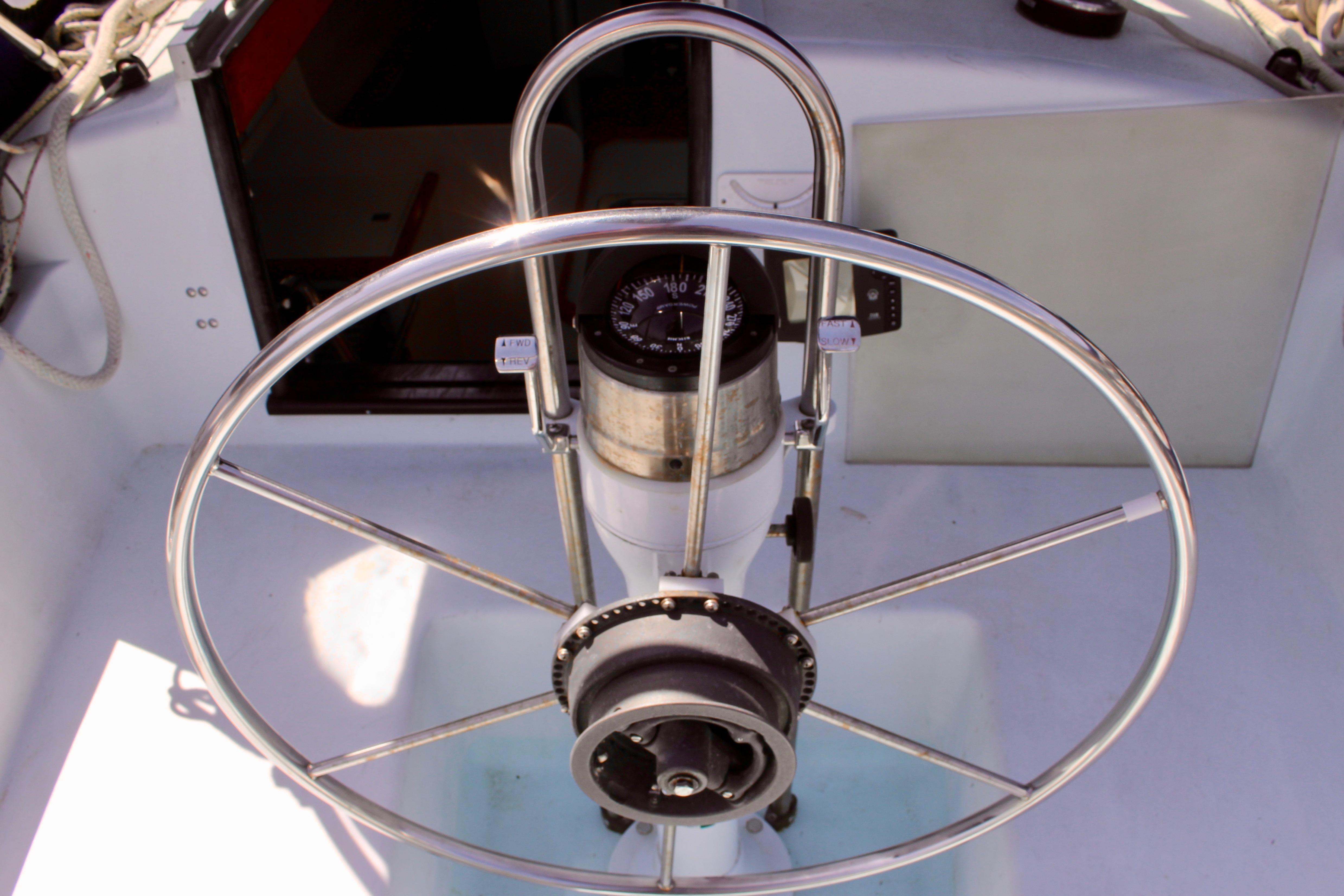 Steering wheel of a 1993 Freya 39 sailboat, featuring a compass and control panel.