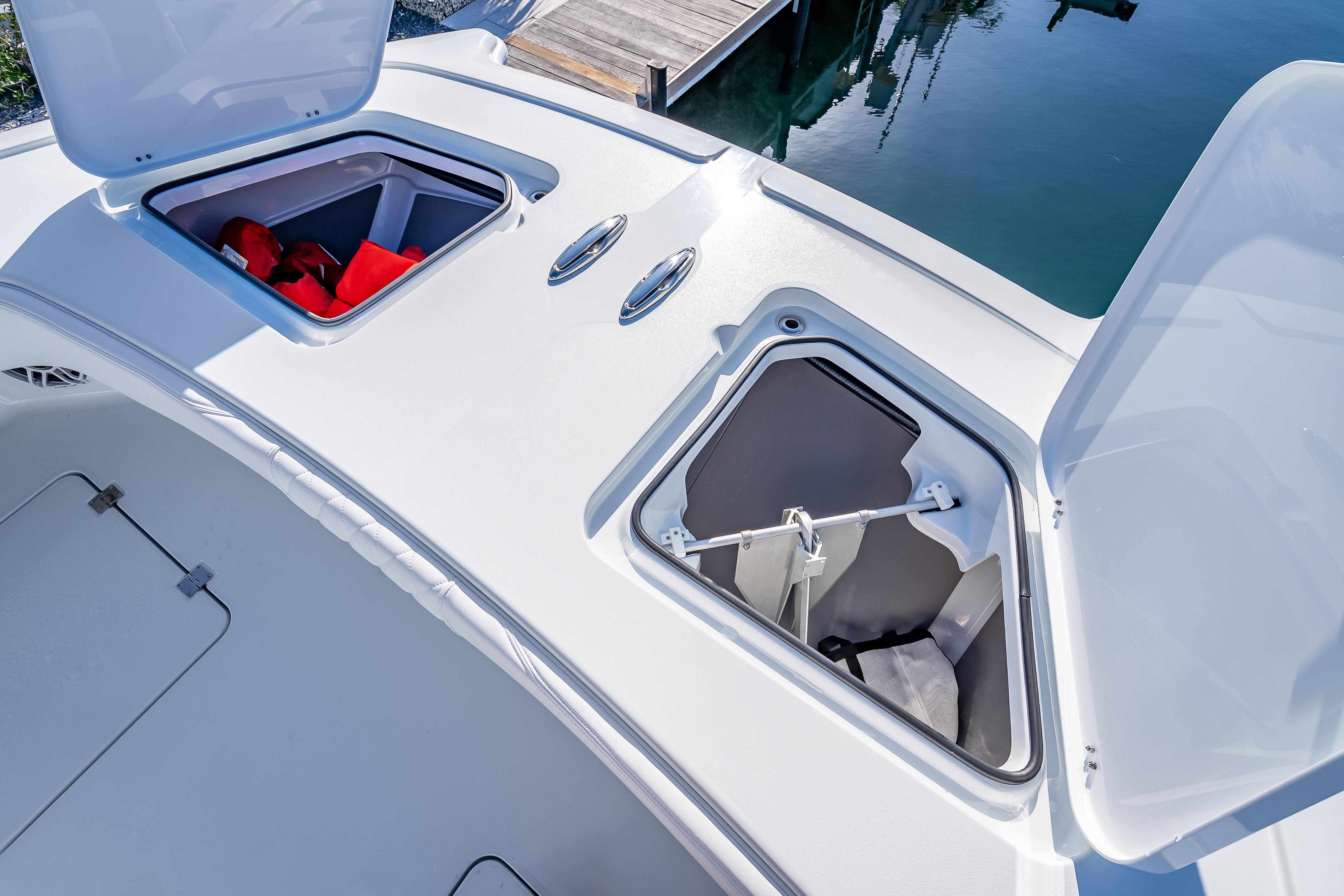Open storage compartments on a 2026 Freeman 35 boat deck, featuring life jackets and equipment.