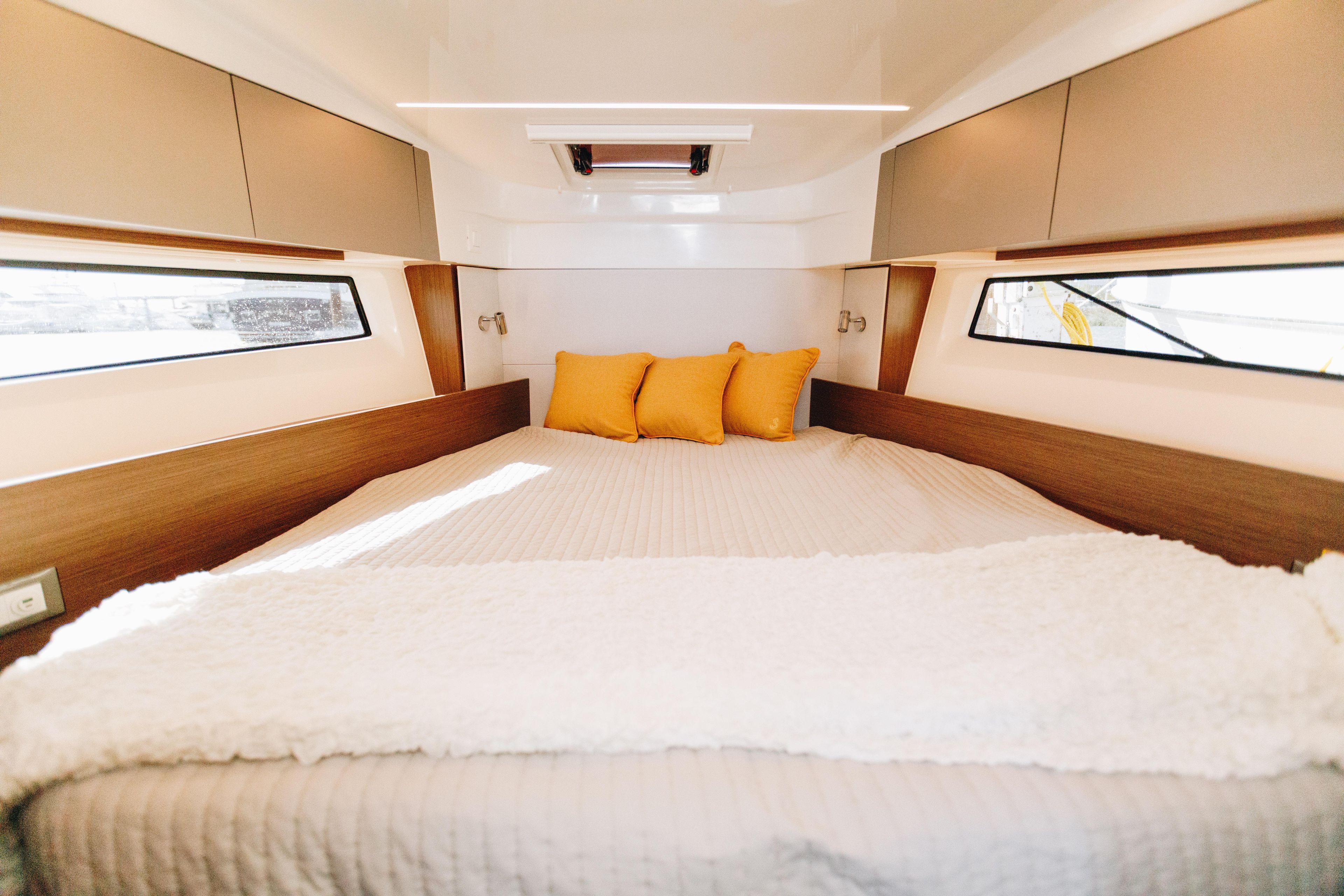 Luxurious cabin interior of 2026 Beneteau Antares 9 with cozy bedding.