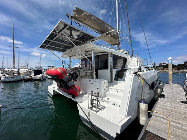 2021 Bali 4.8 catamaran docked at marina with solar panels and dinghy.