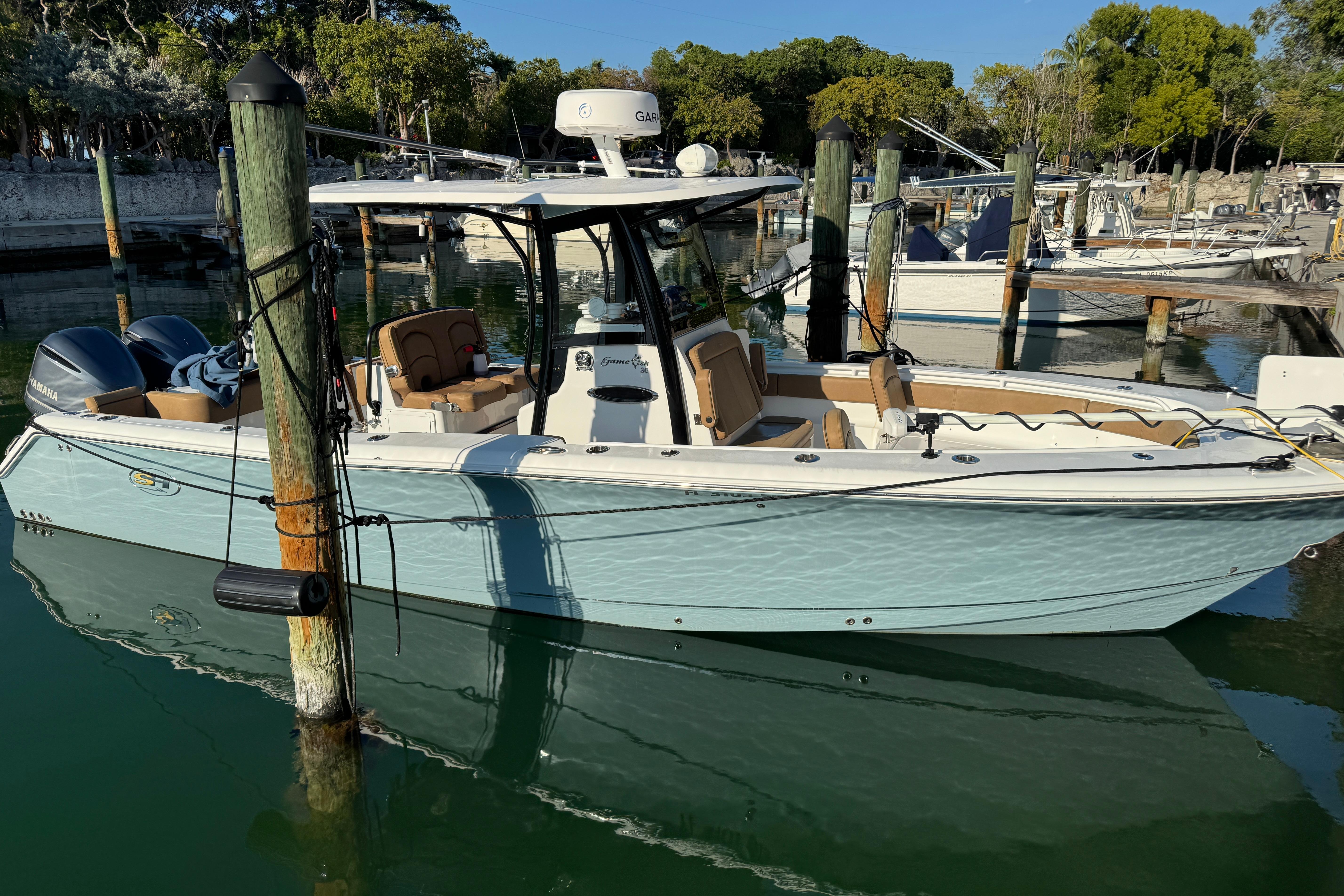 2021 Sea Hunt Gamefish 30 boat docked in a marina, featuring forward seating.