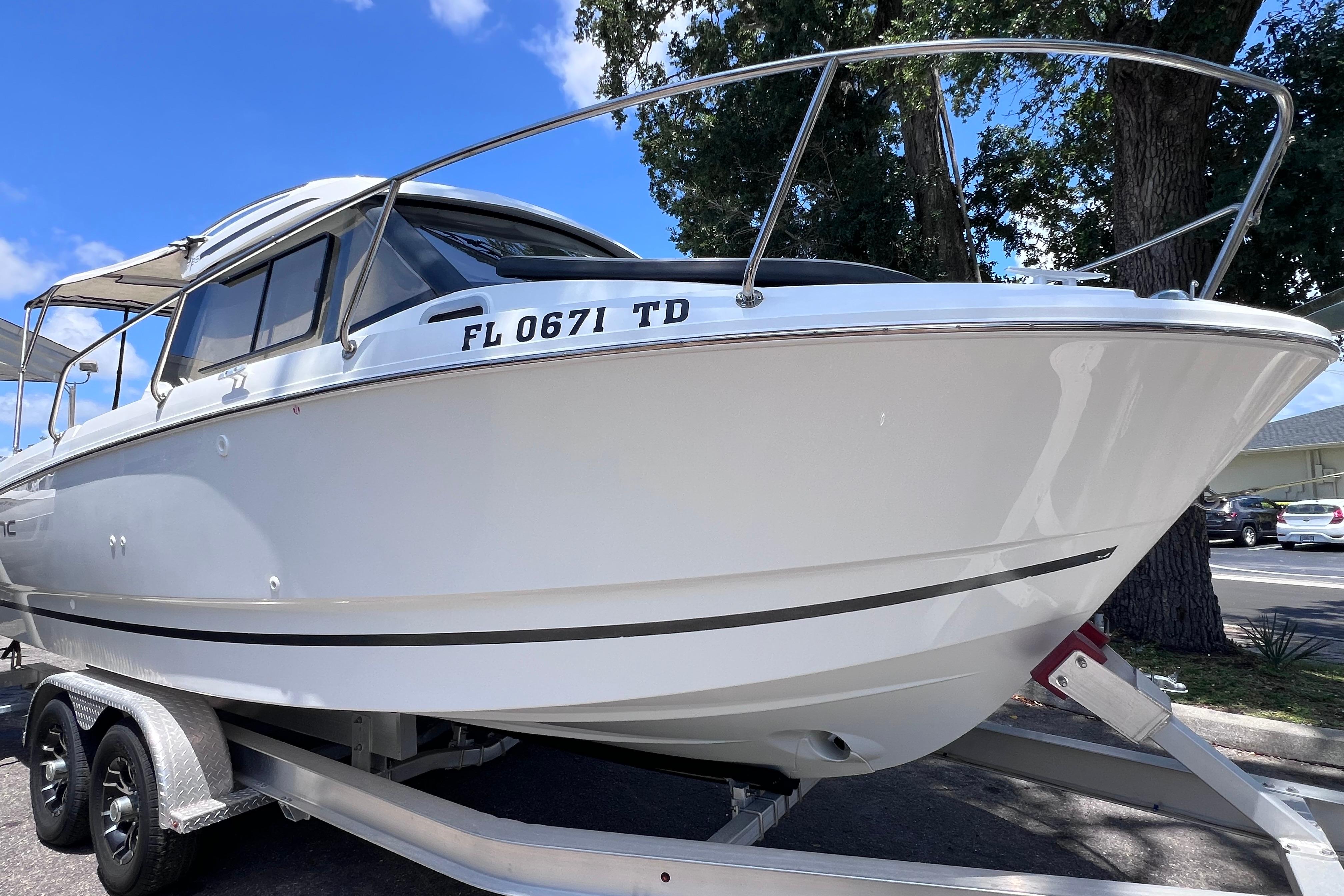 2021 Jeanneau NC Weekender 795 Series 2 boat on trailer, parked outdoors.