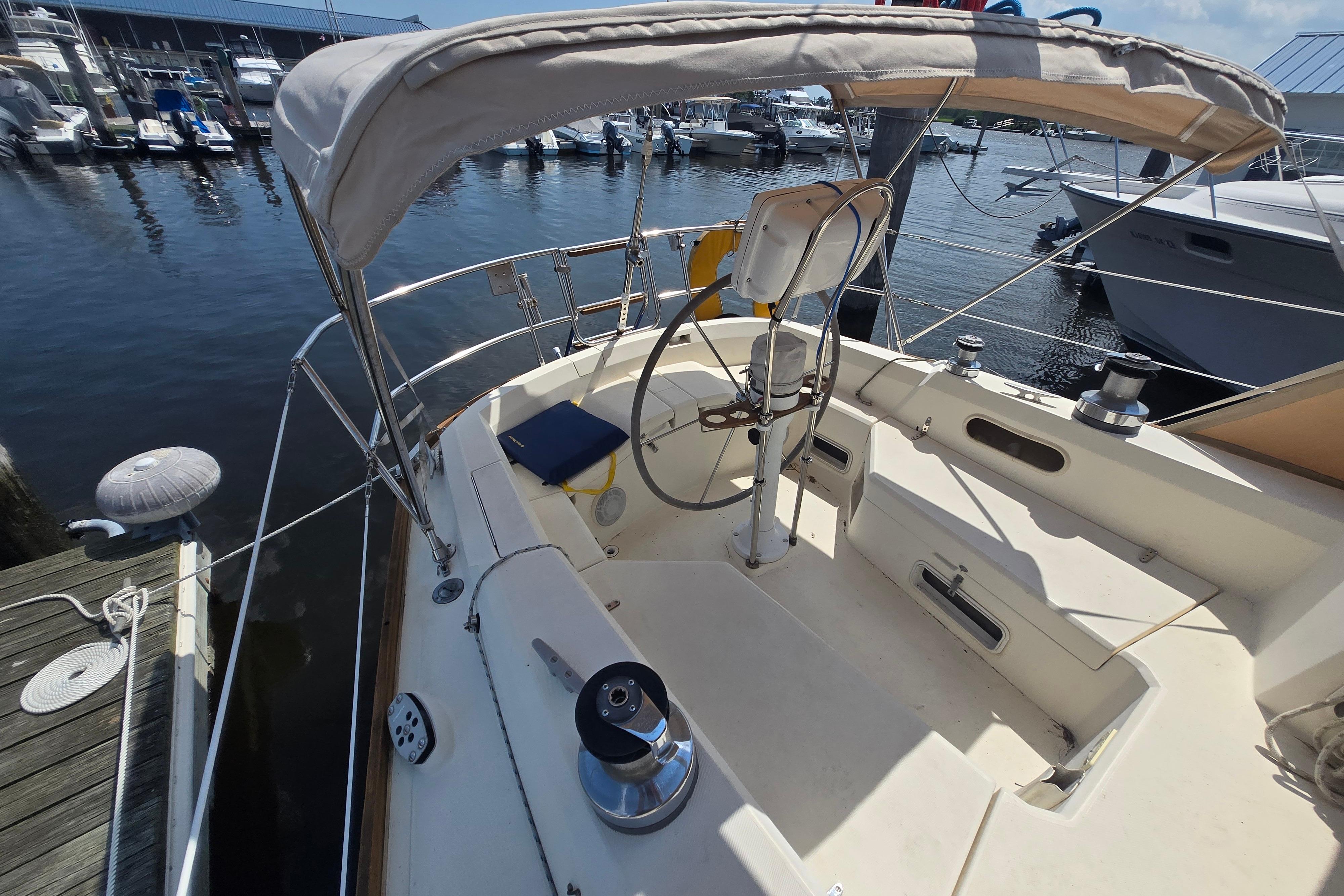 1988 Sabre 38 sailboat cockpit with canopy, docked at marina.
