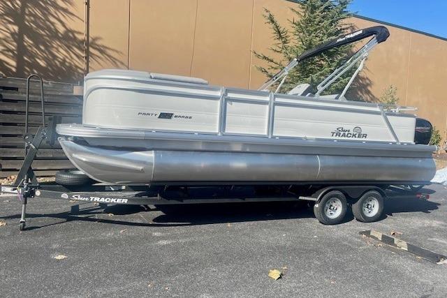 2026 Sun Tracker Party Barge 22 RF DLX pontoon boat on trailer, parked outdoors.