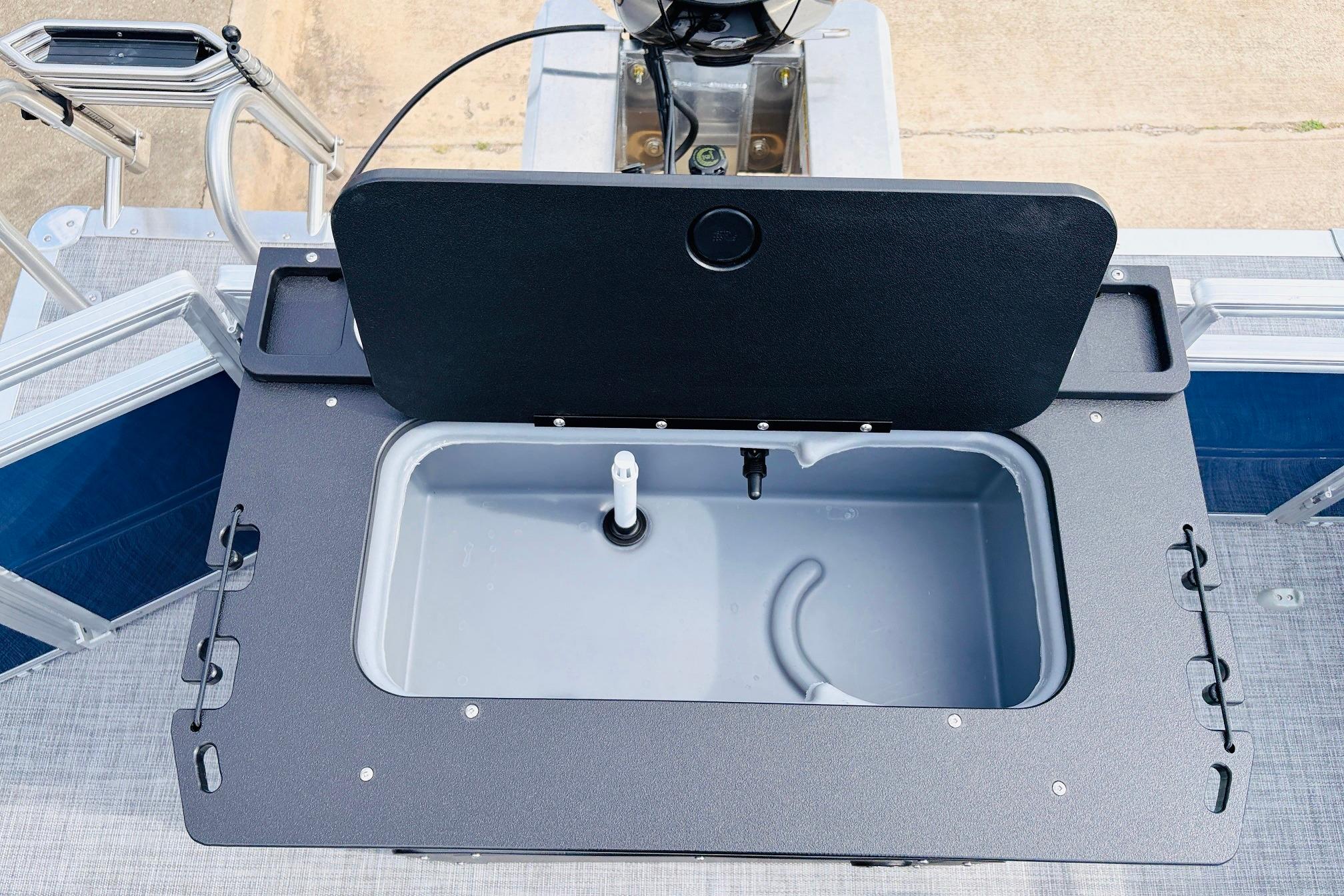 2026 Sun Tracker SportFish 22 DLX livewell with open lid, showcasing interior features.