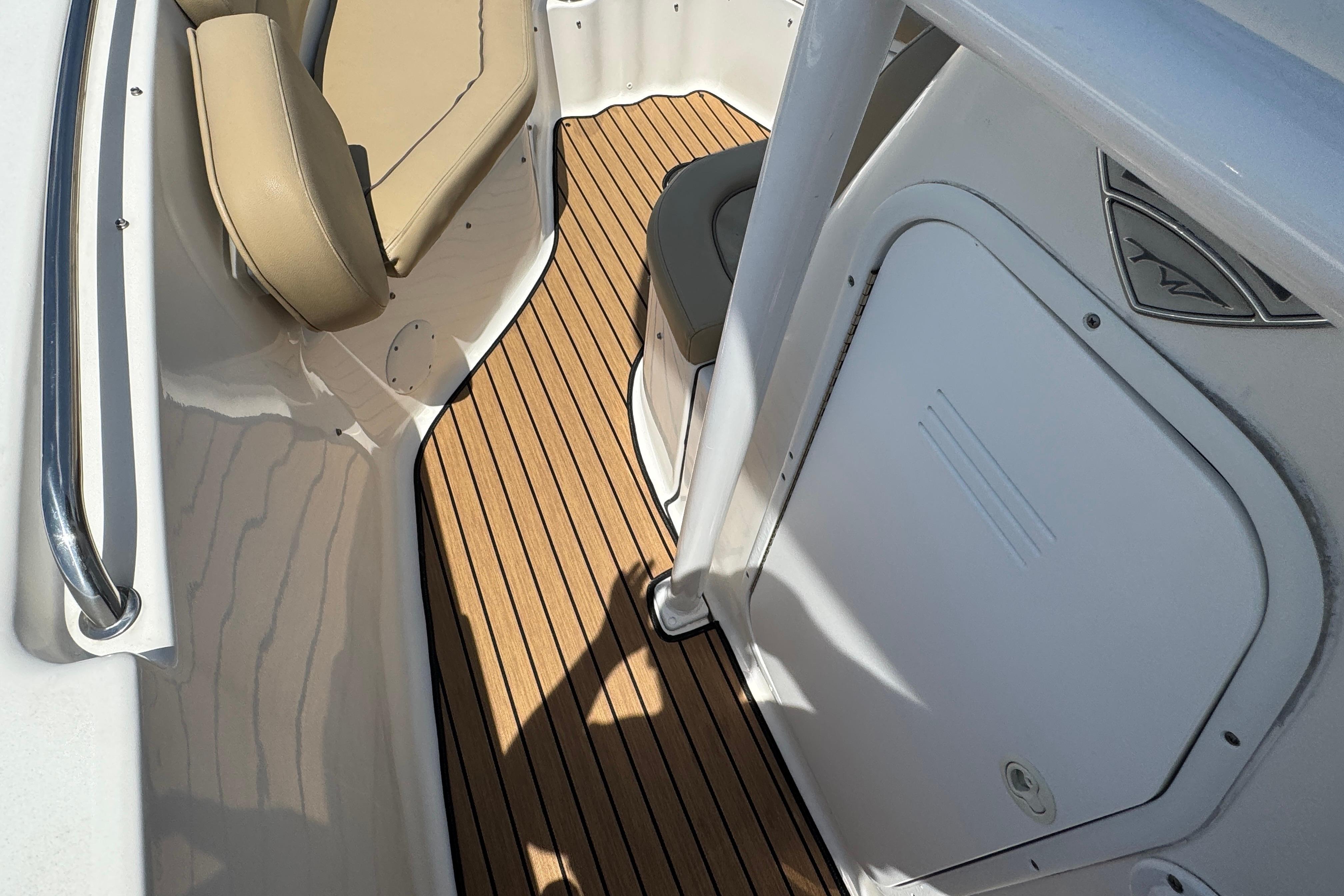 2016 Tidewater 230 LXF boat interior with teak flooring and beige seating.