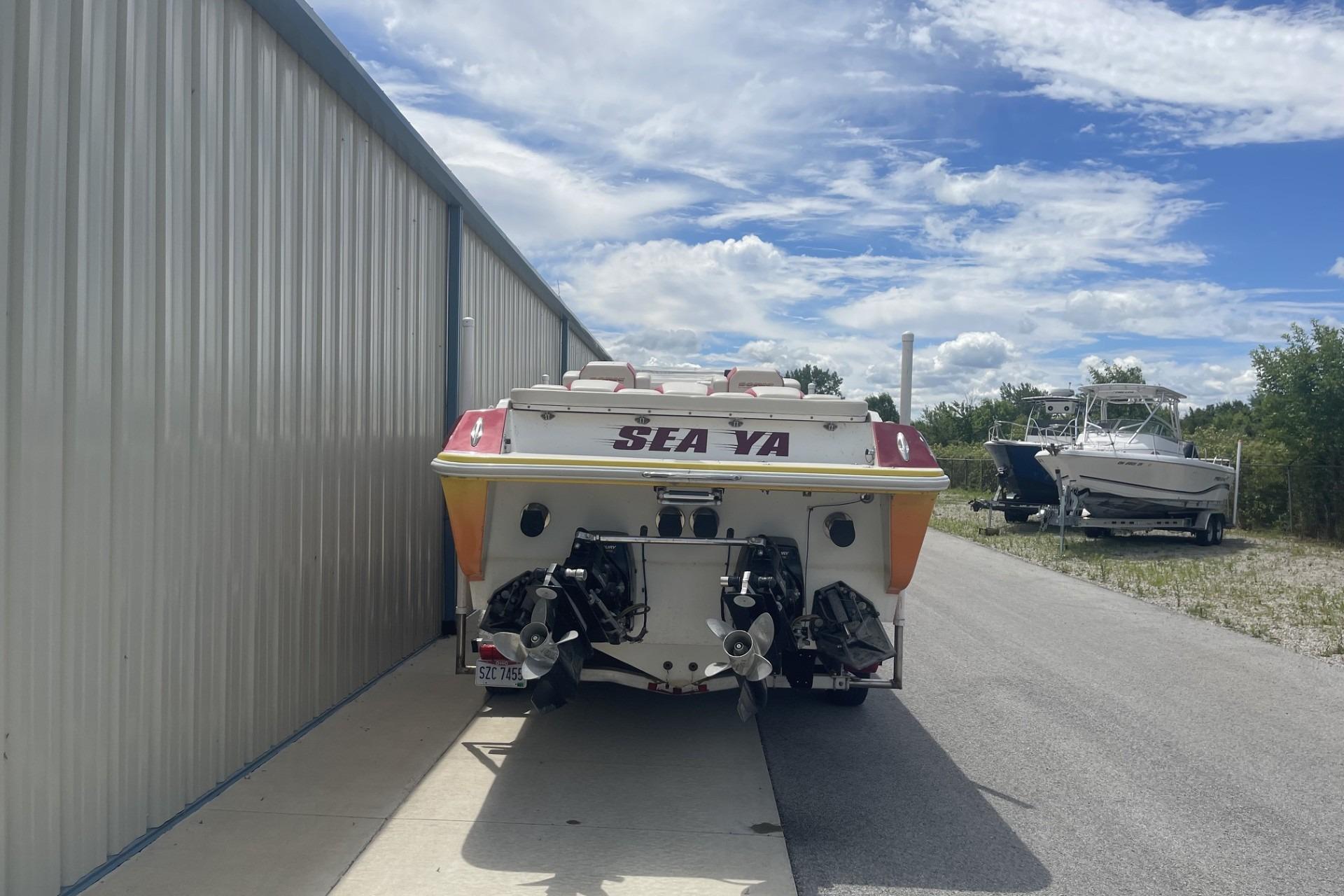 2006 Sonic 386 boat parked beside a metal building under a partly cloudy sky.