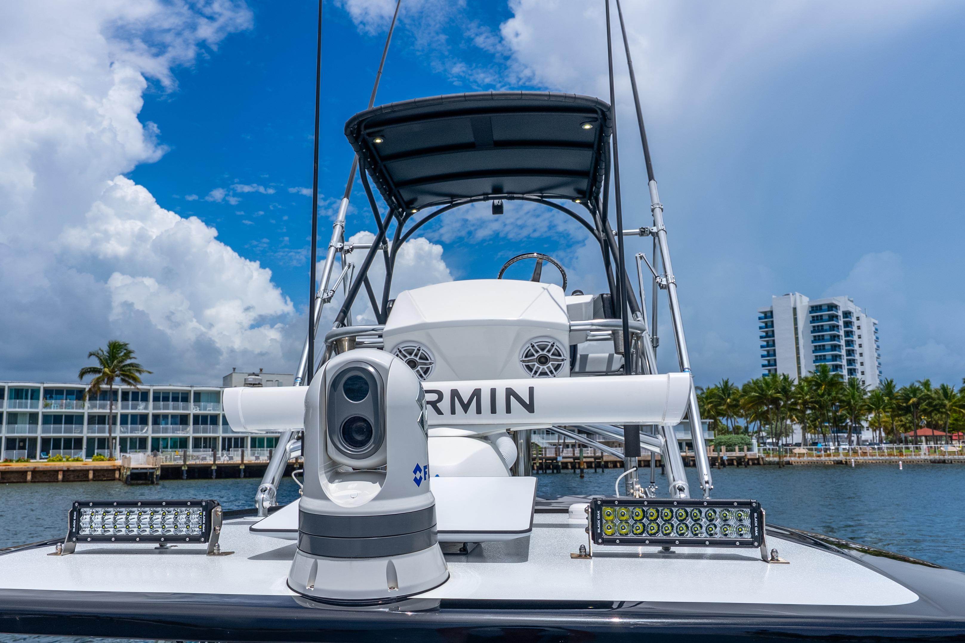 2024 Nor-Tech 452 Super Fish boat with advanced navigation equipment, docked near modern buildings.