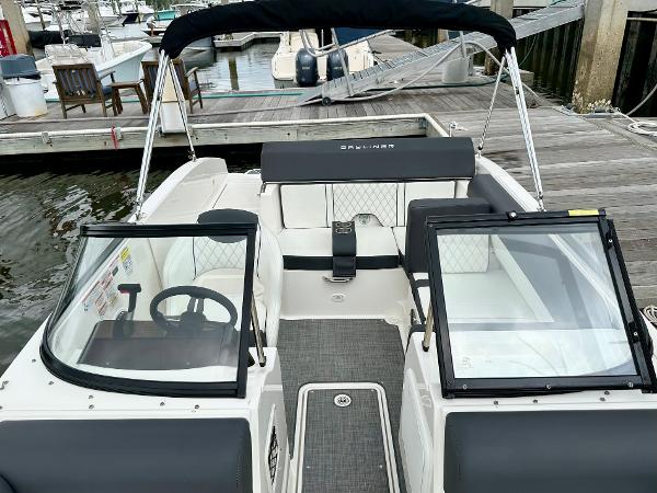 2022 Bayliner DX 2050 boat interior at dock, featuring seating and steering wheel.