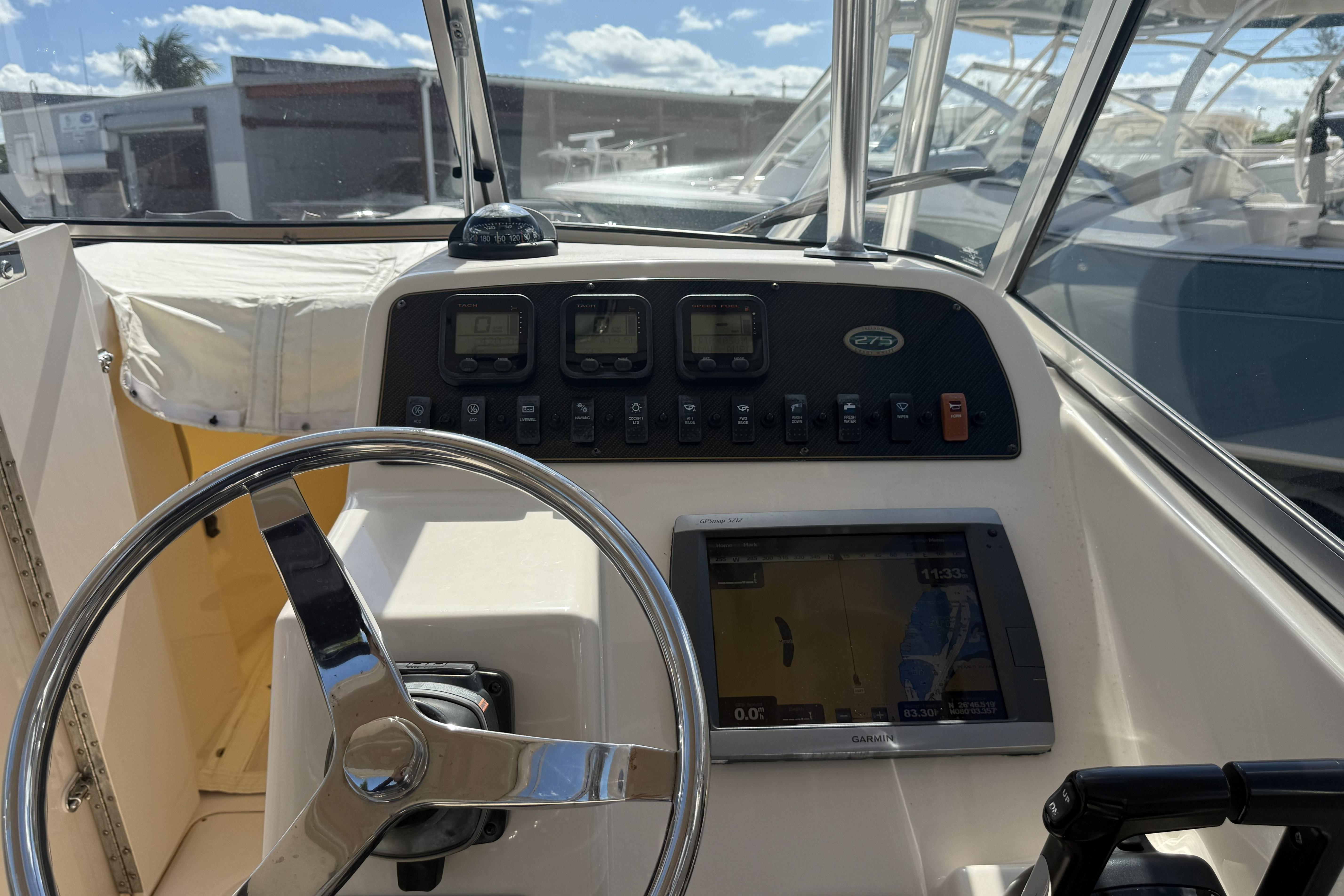 2014 Grady-White Freedom 275 boat dashboard with steering wheel and navigation controls.