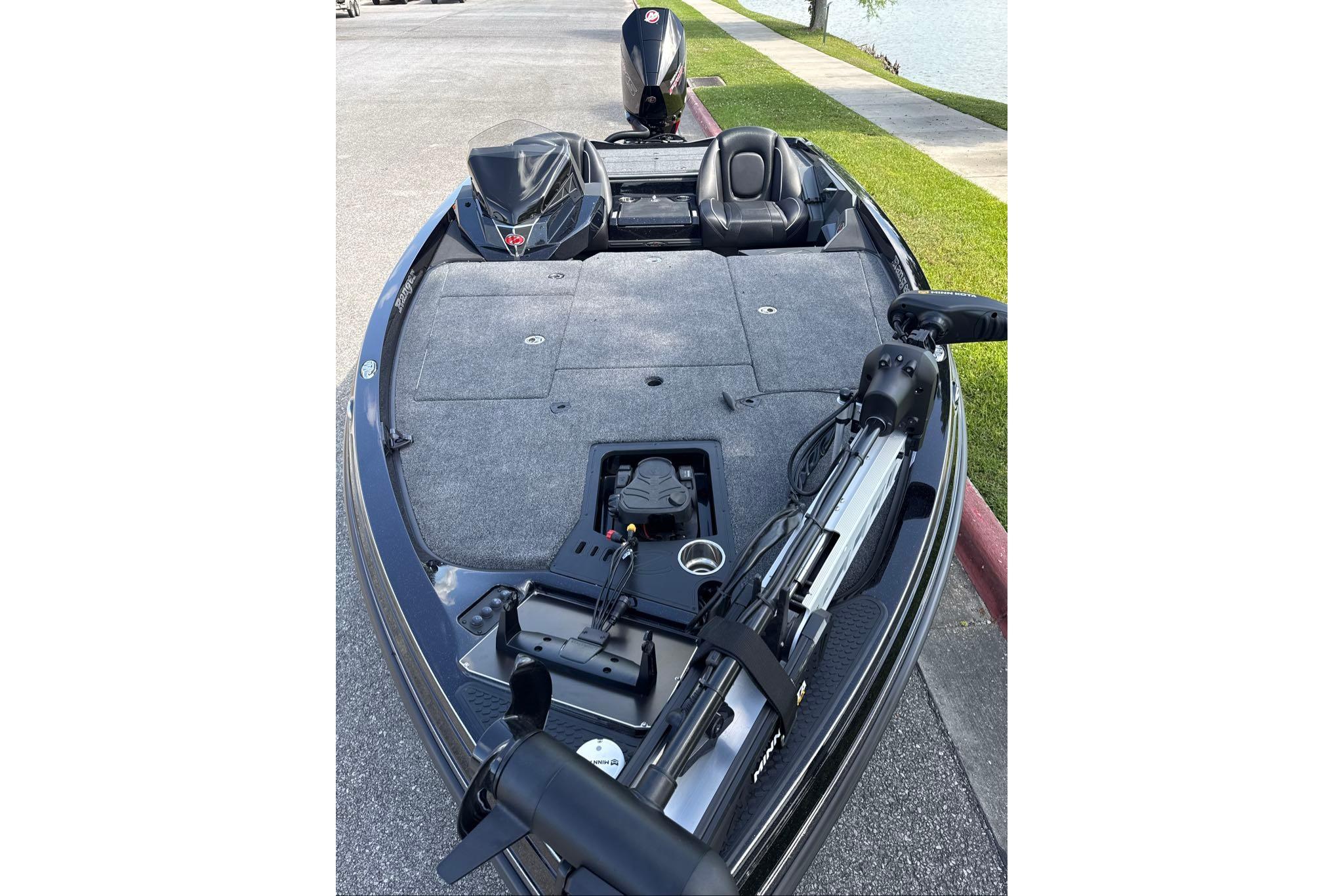 2026 Ranger Z518 boat with fishing deck and motor, parked by a lakeside.